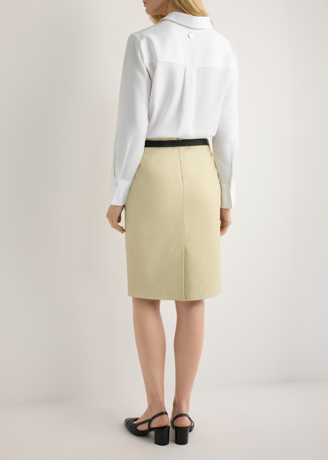Žltá kožená sukňa SPCDS-0031-2A(W26), pohľad zozadu na produkt na modelke. Viditeľná polovica siluety.
