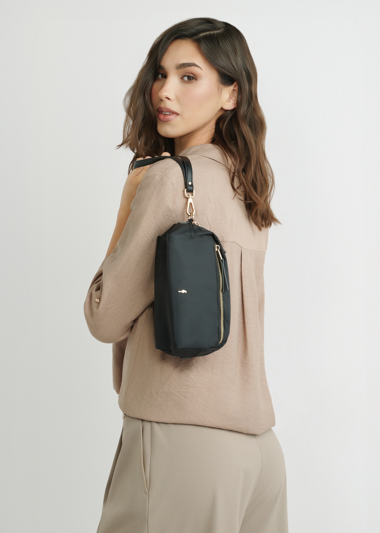 Čierna dámska kozmetická taška TOREN-0347-99(W26), pohľad na produkt na siluete modelky, na svetlom pozadí.