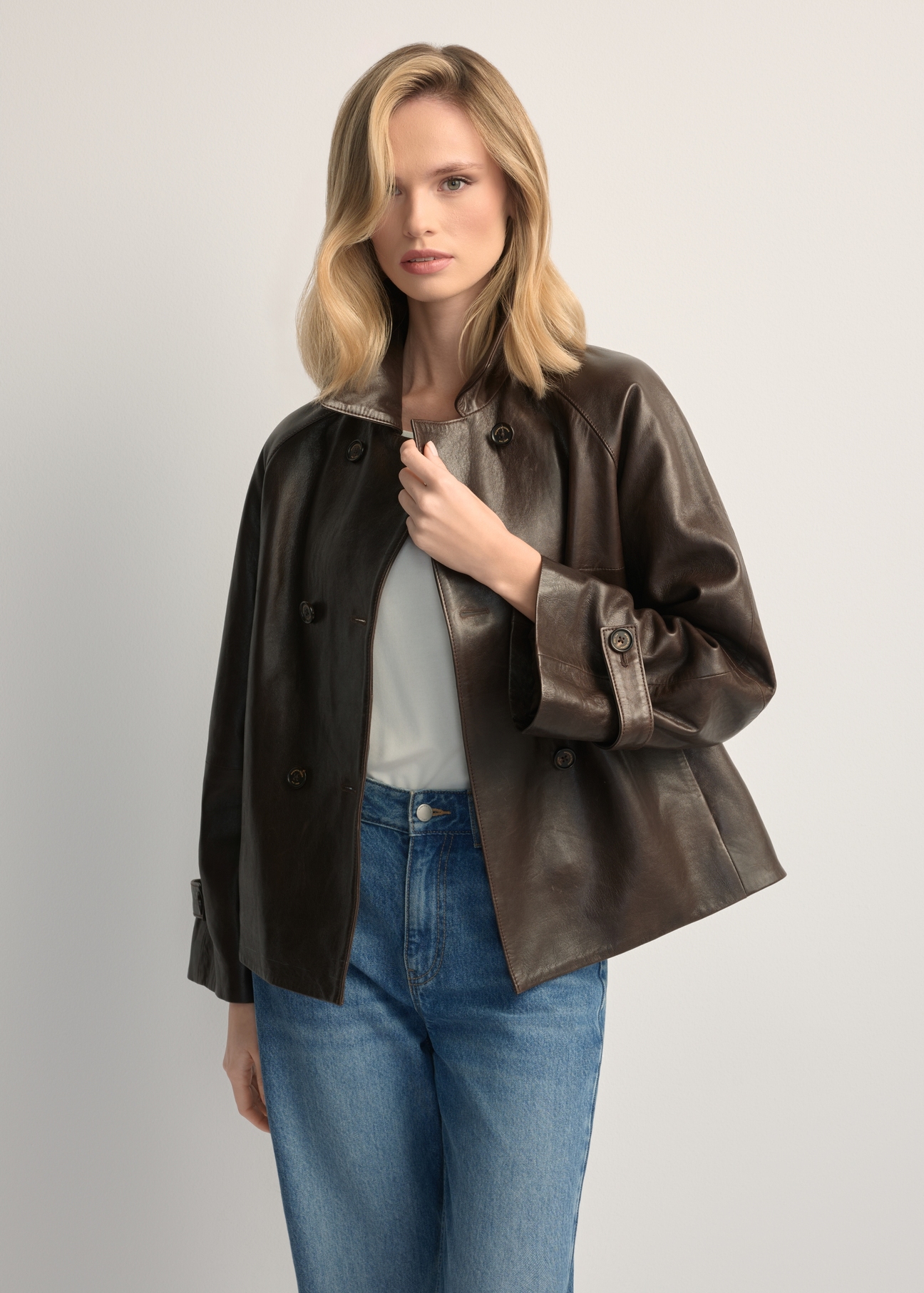 Dámska tmavohnedá kožená bunda KURDS-0604-1I(W26), pohľad spredu na produkt na modelke. Viditeľná polovica siluety.