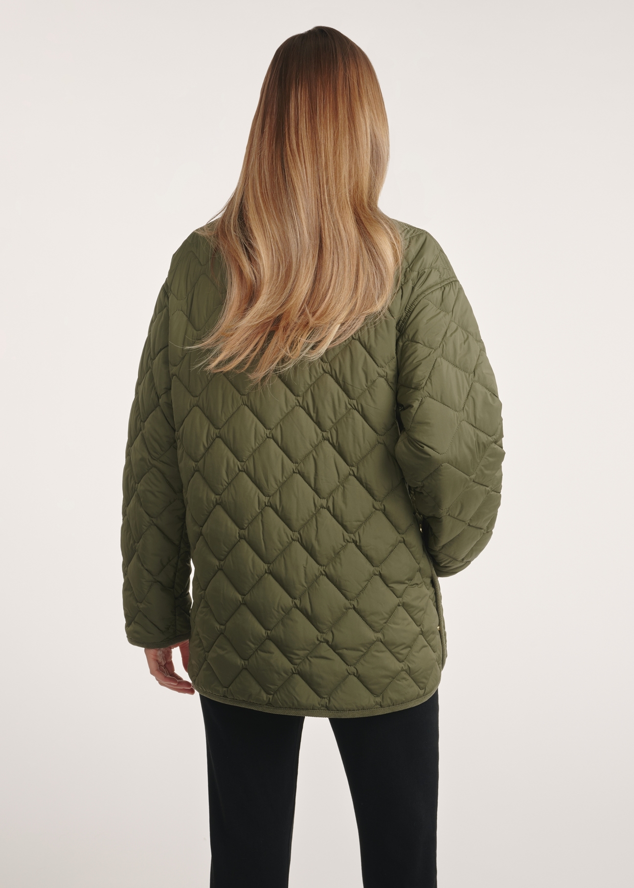 Dámska bunda s golierom v khaki farbe KURDT-0596-55(Z25), pohľad na produkt zozadu na modeli. Je viditeľná polovica siluety.