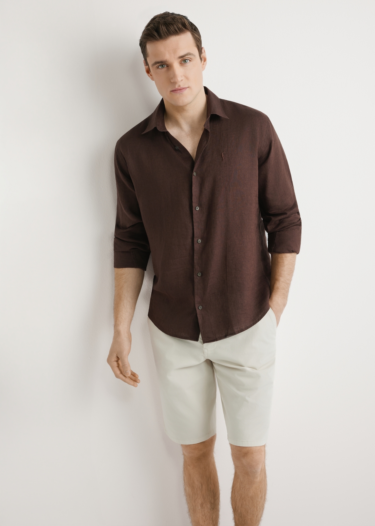Hnedá pánska ľanová košeľa KOSMT-0321A-1I(W26) - pohľad spredu na produkt, na modelke, na svetlom pozadí. Viditeľná silueta po kolená.
