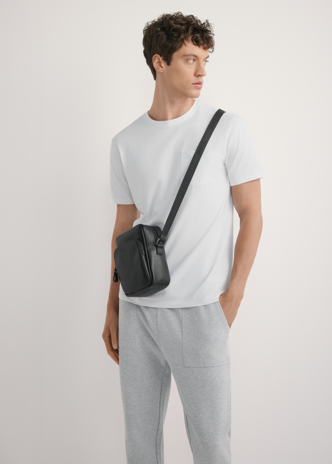 Čierna pánska kožená taška TORMS-0485R-9I(W26), pohľad spredu na produkt na modelke, viditeľná polovica siluety.