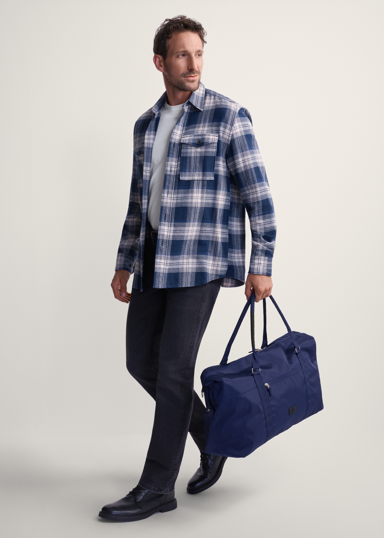 Námornícka modrá cestovná taška TORMN-0382-69 (Z25), pohľad na produkt v ruke modelky. Viditeľné celé telo.