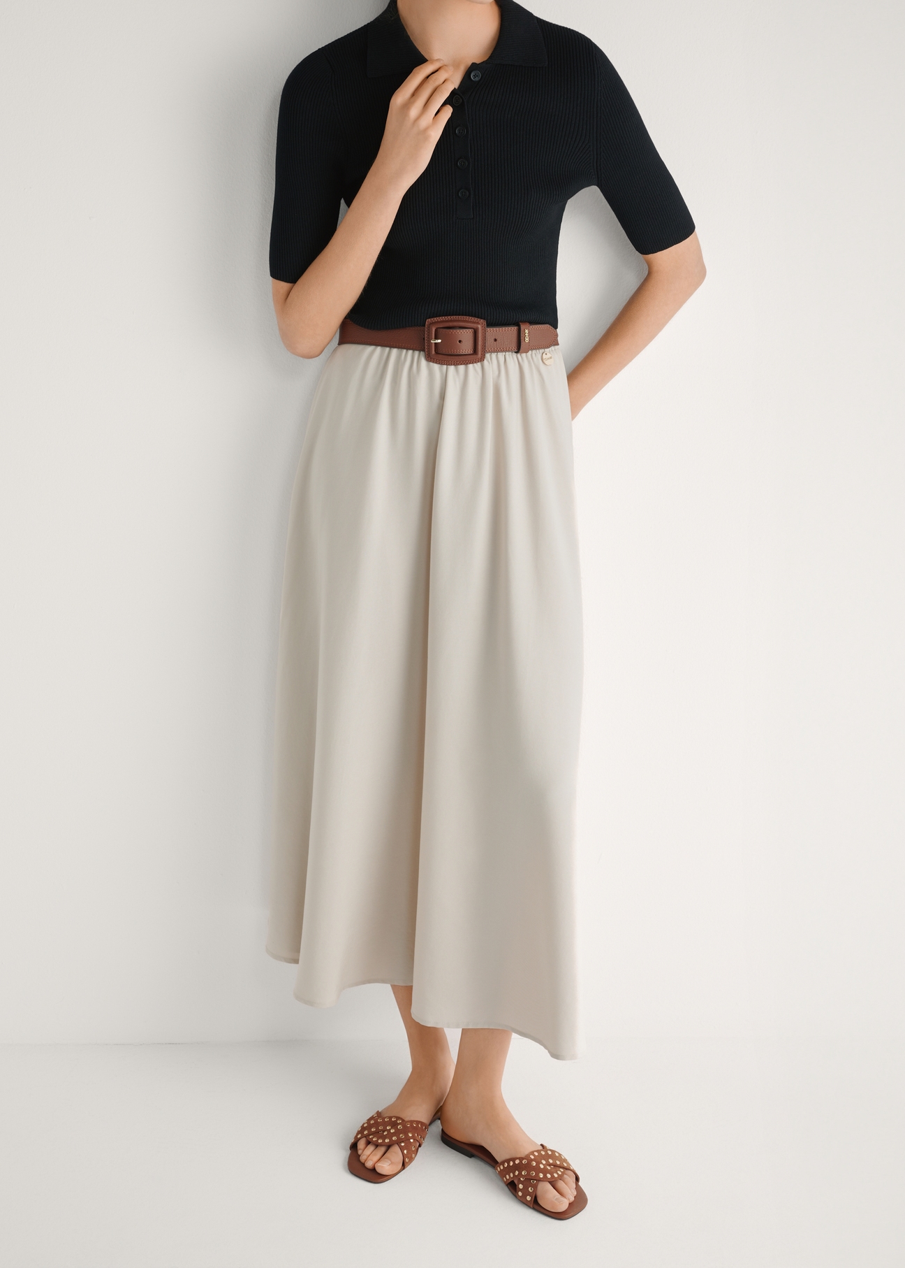 Dámske šľapky z ťavej kože s kamienkami BUTYD-1226-1D(W26), pohľad spredu na modelkine nohy, na bielom pozadí.