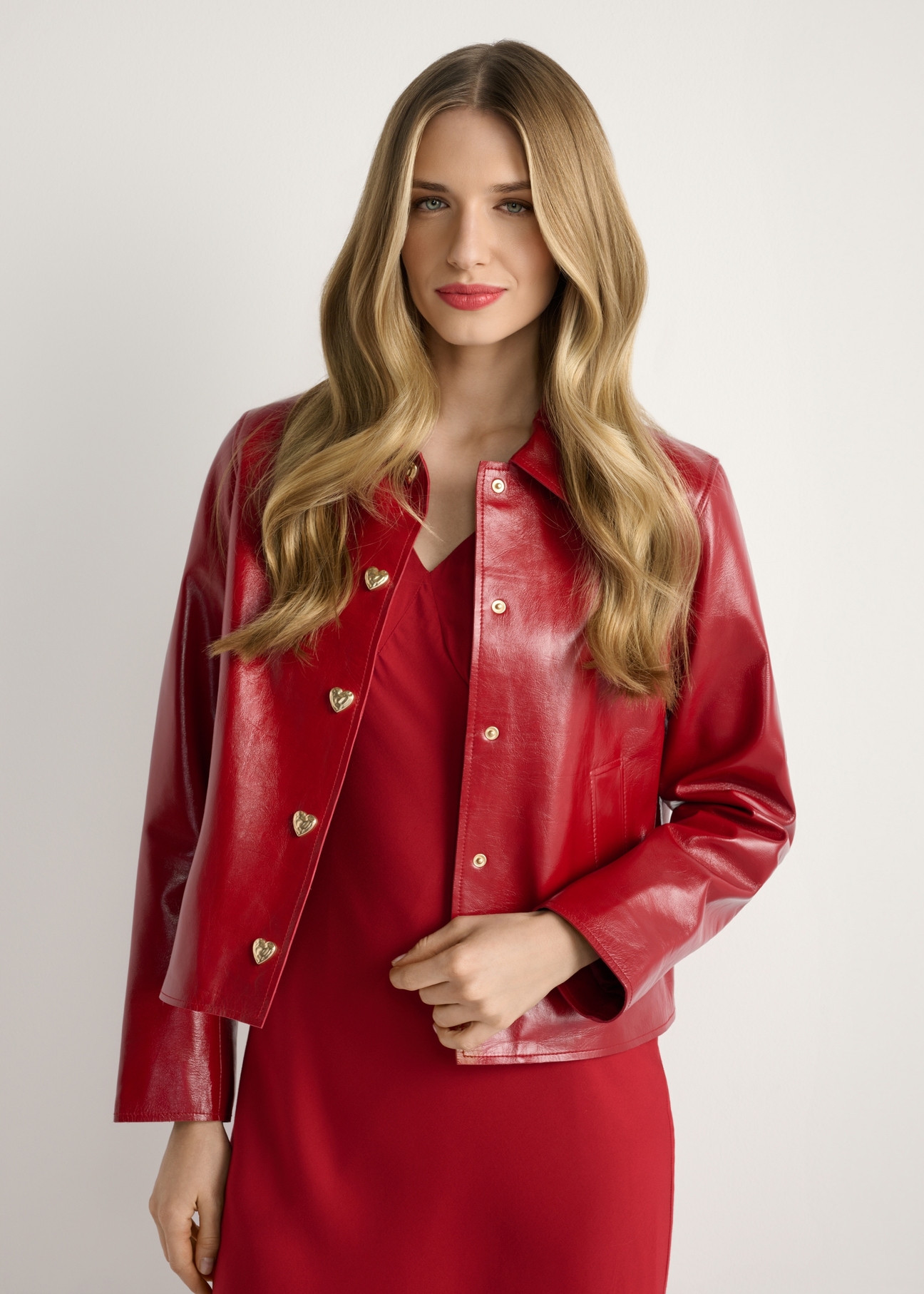 Červená krátka dámska bunda KURDS-0612-4B(W26), pohľad na produkt spredu na modelke, viditeľná polovica siluety.