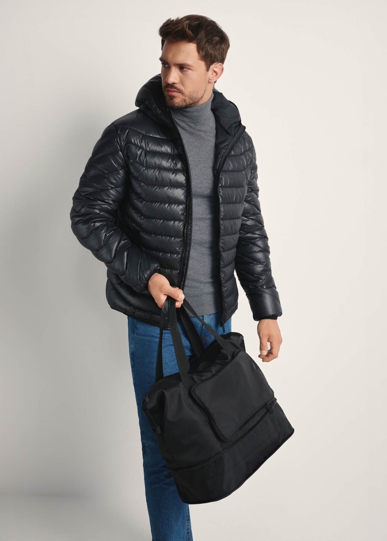 Čierna pánska taška TORMN-0369-99(Z25), diagonálny pohľad na produkt na modelke, viditeľná polovica siluety.