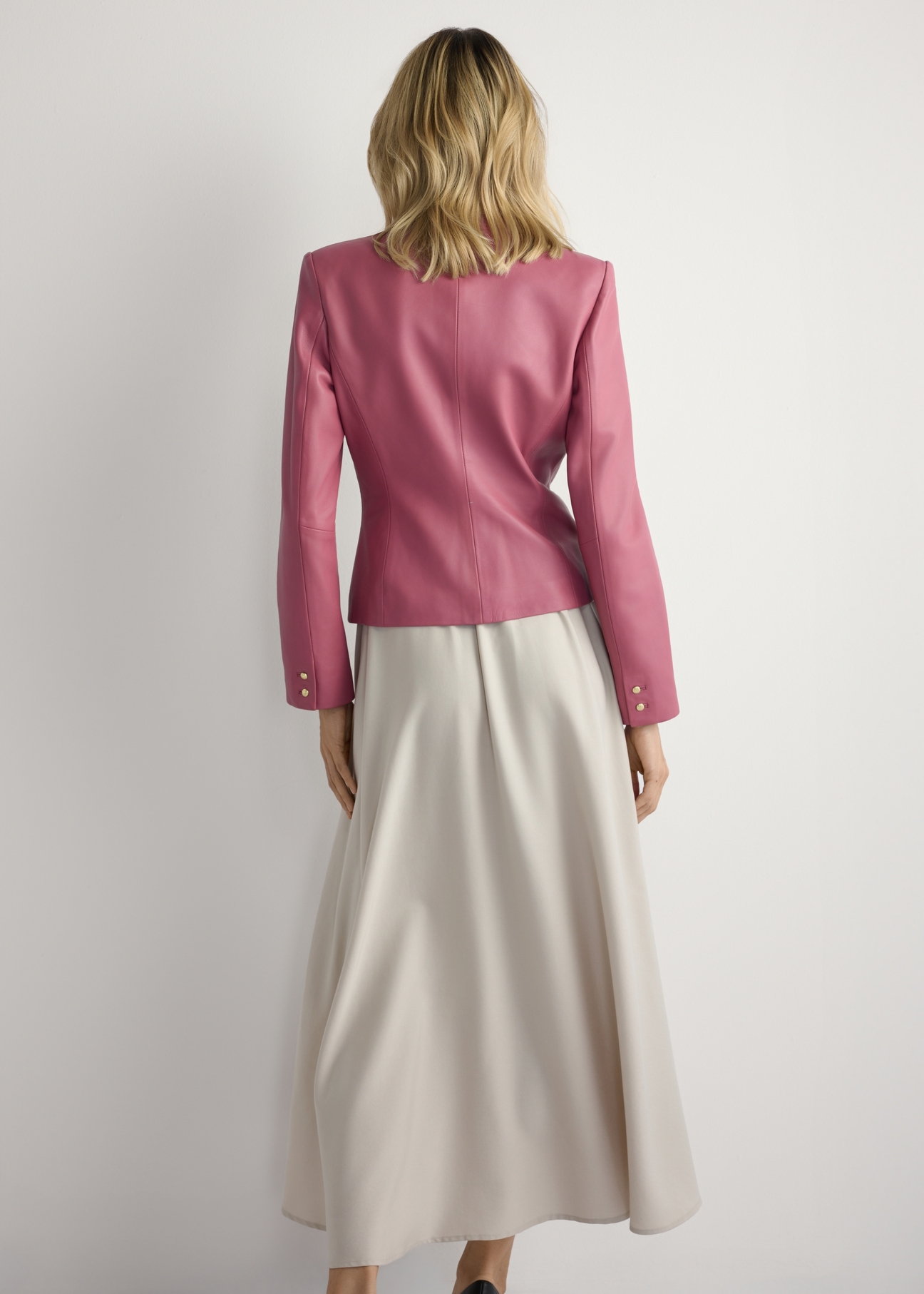 Dámska ružová kožená bunda KURDS-0599-5D(W26) - pohľad na výrobok zozadu, na modelke, na svetlom pozadí. Viditeľné celé telo.