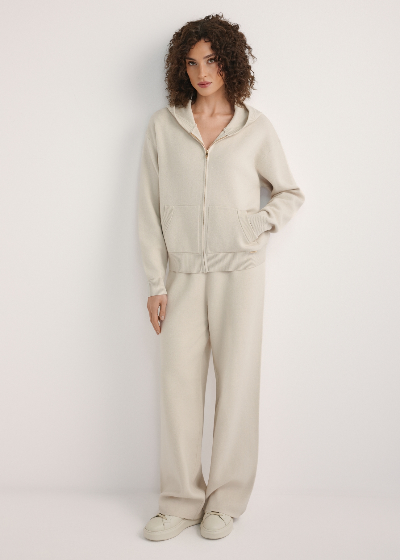 Dámska béžová mikina s kapucňou BLZDT-0120-1A(W26), pohľad na produkt spredu na modelke. Viditeľné celé telo.