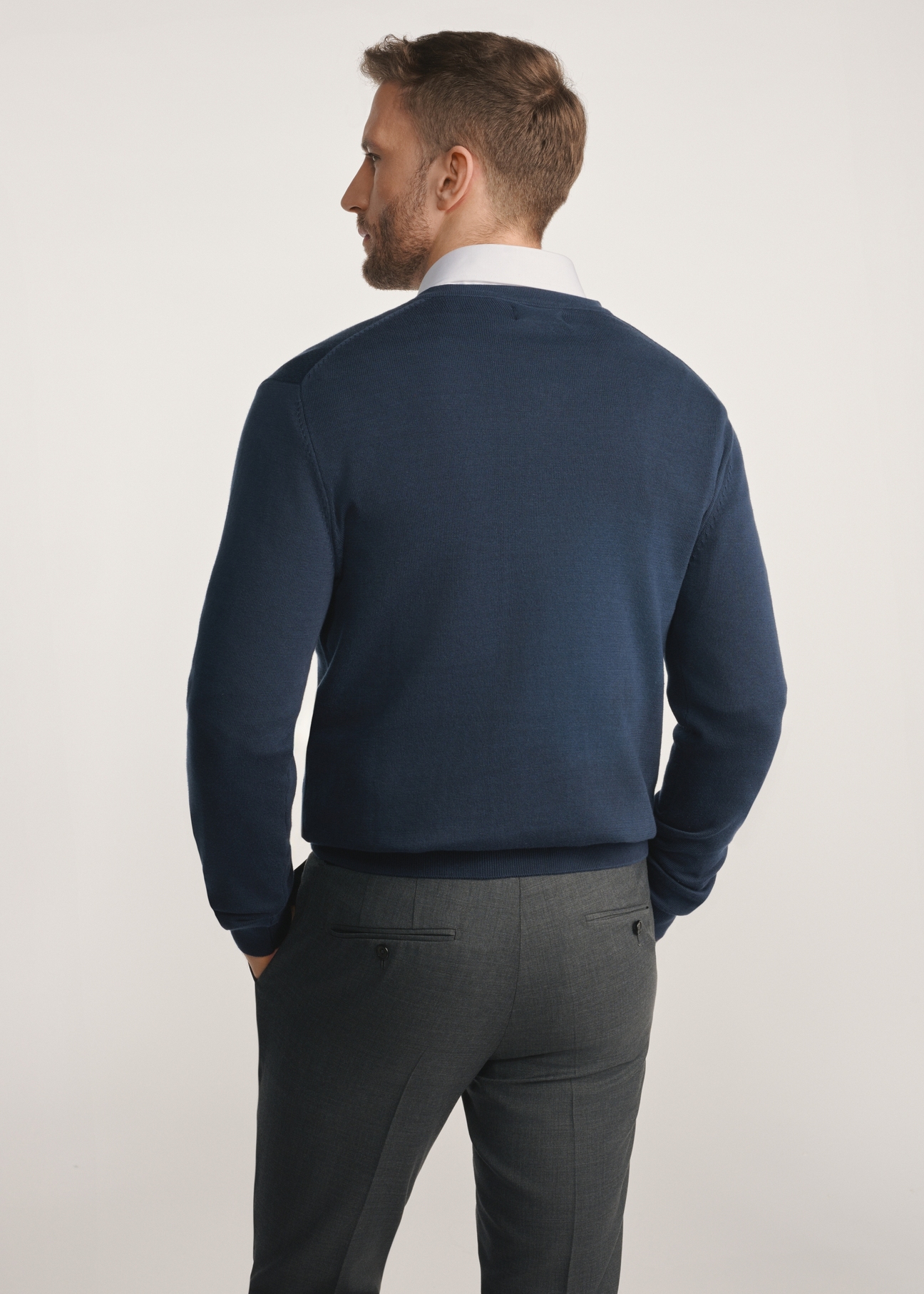 Pánsky tmavomodrý sveter s logom SWEMT-0159A-68(Z25) - pohľad na produkt zozadu na modelke na bielom pozadí. Viditeľná polovica siluety.