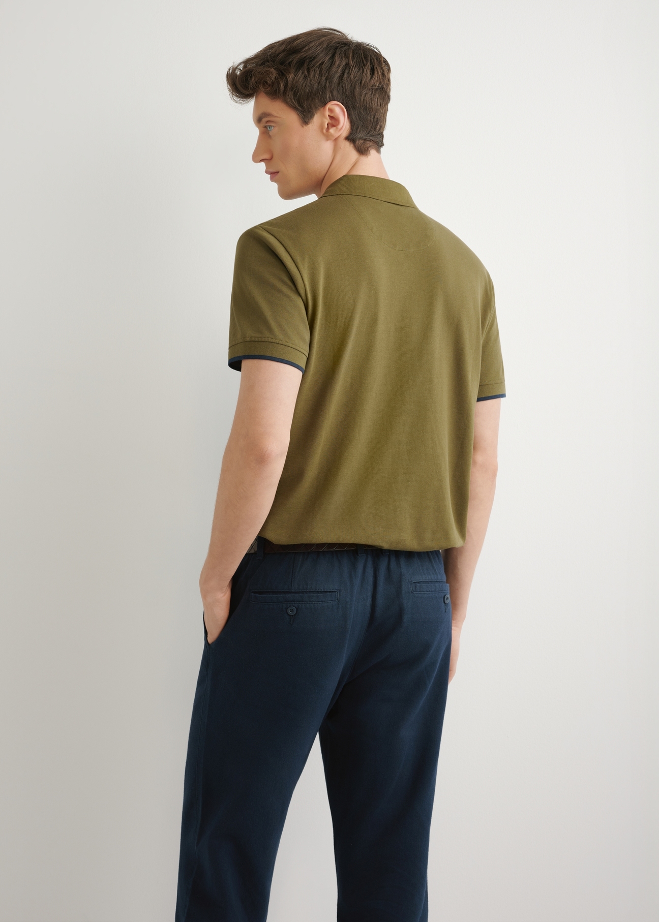 Bavlnené polo tričko v khaki farbe POLMT-0045B-8D(W26) - pohľad zozadu na produkt, zobrazený na modelke na svetlom pozadí. Viditeľná je silueta polovičnej dĺžky.