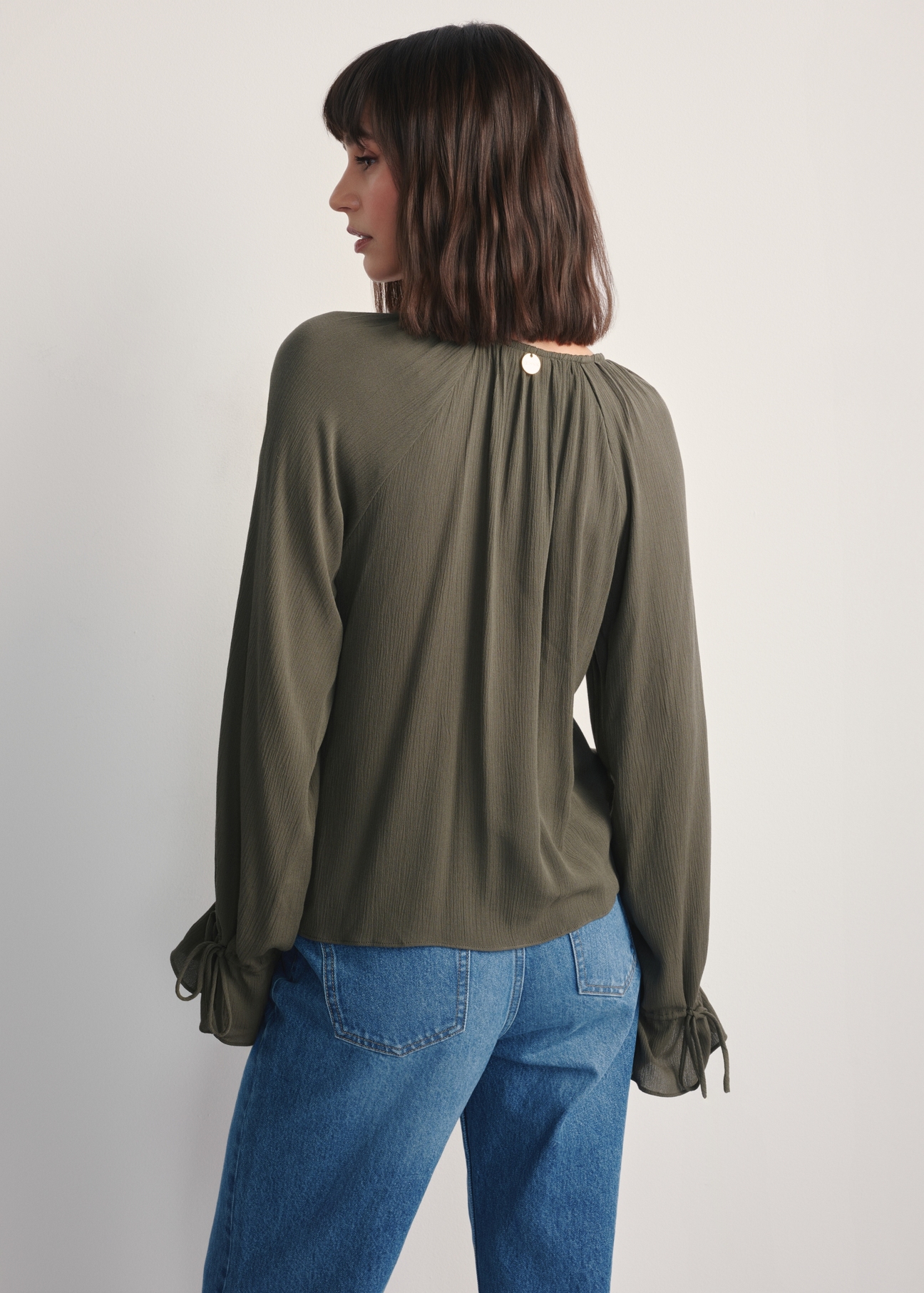 Dámska khaki blúzka BLUDT-0194-55(Z25), pohľad na produkt zozadu na modelke, viditeľná polovica siluety.