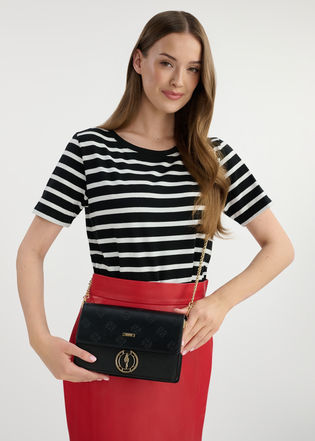 Čierna dámska kabelka s monogramom TOREC-0536B-99(W25), pohľad spredu na produkt na modeli. Viditeľná je polovica siluety.