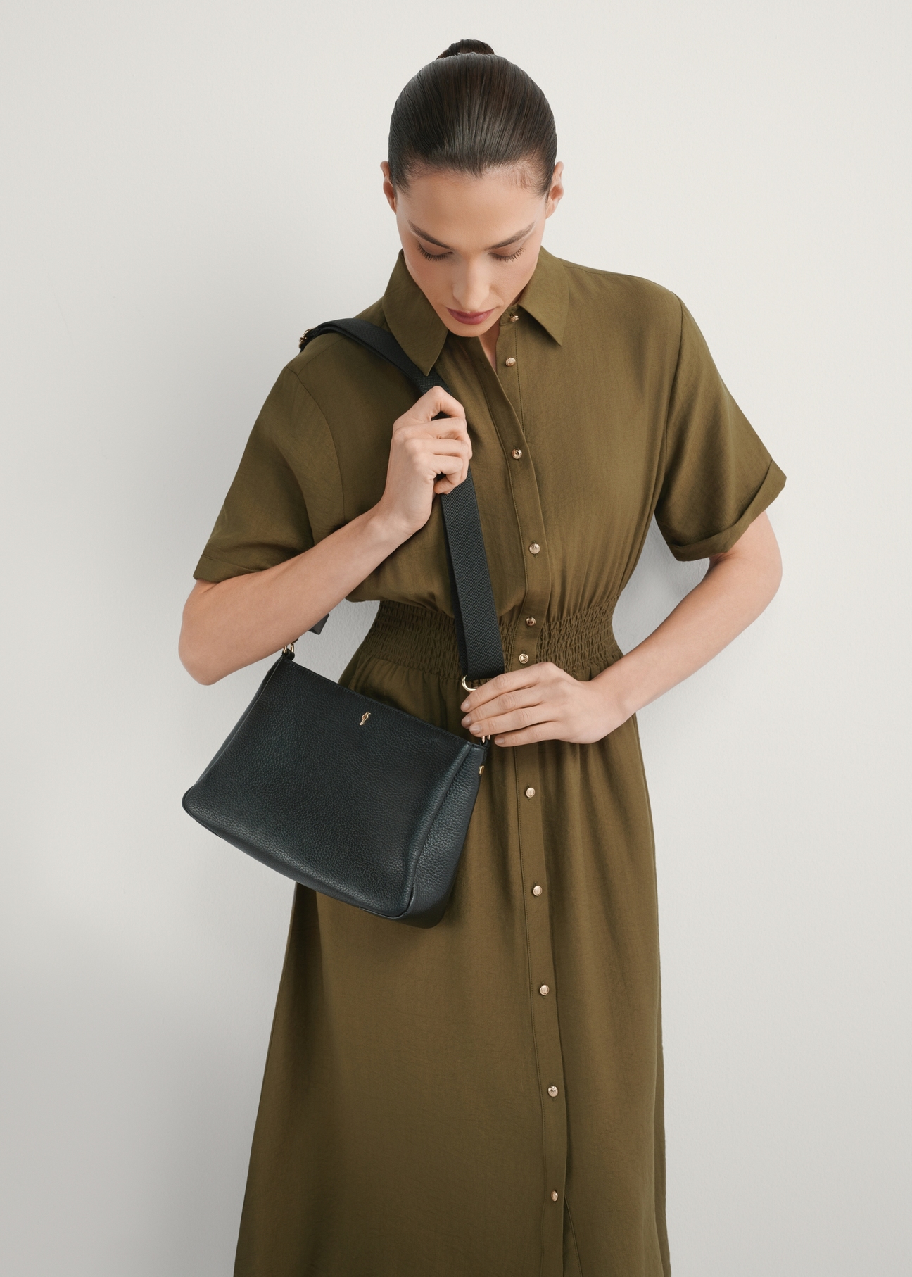 Dámska čierna kožená taška cez rameno TORES-1214-9I(W26), pohľad spredu na produkt na modelke, viditeľná polovica siluety.