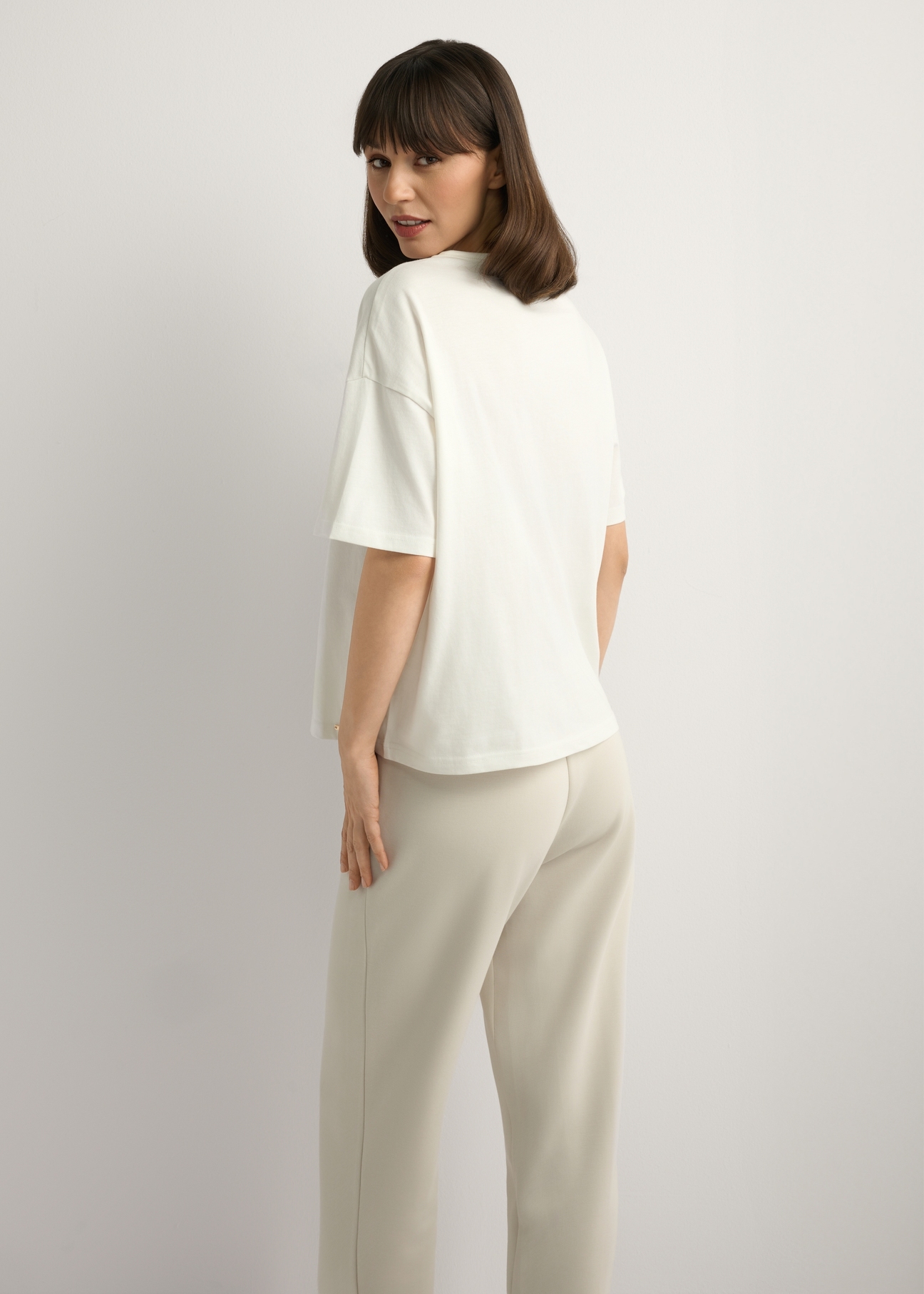 Dámske krémové tričko s potlačou TSHDT-0161-0B(W26), pohľad na produkt zozadu na modelke. Viditeľná polovica siluety.