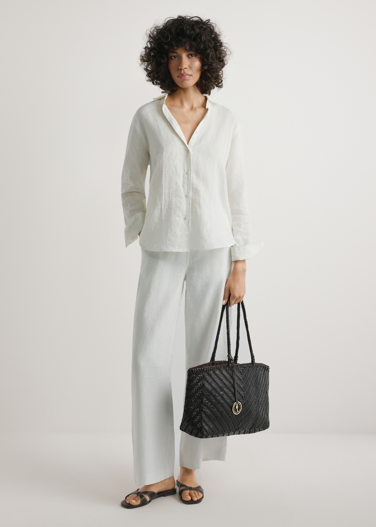 Tmavohnedá tkaná dámska kabelka TORES-1301-1I(W26), pohľad na produkt v ruke modelky. Viditeľné celé telo.