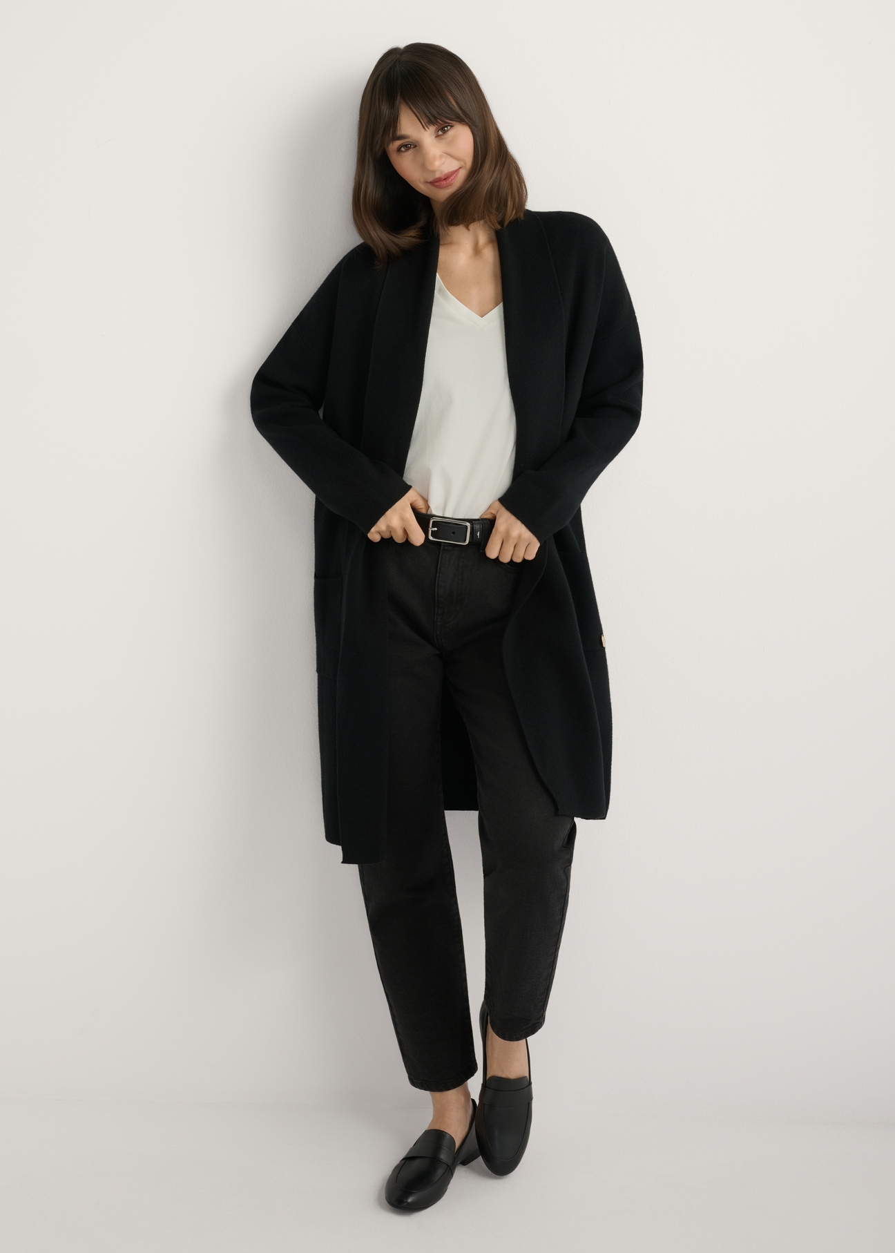 Čierny dámsky základný kardigan KARDT-0041-99(W25), pohľad spredu na produkt na modelke. Viditeľné celé telo.