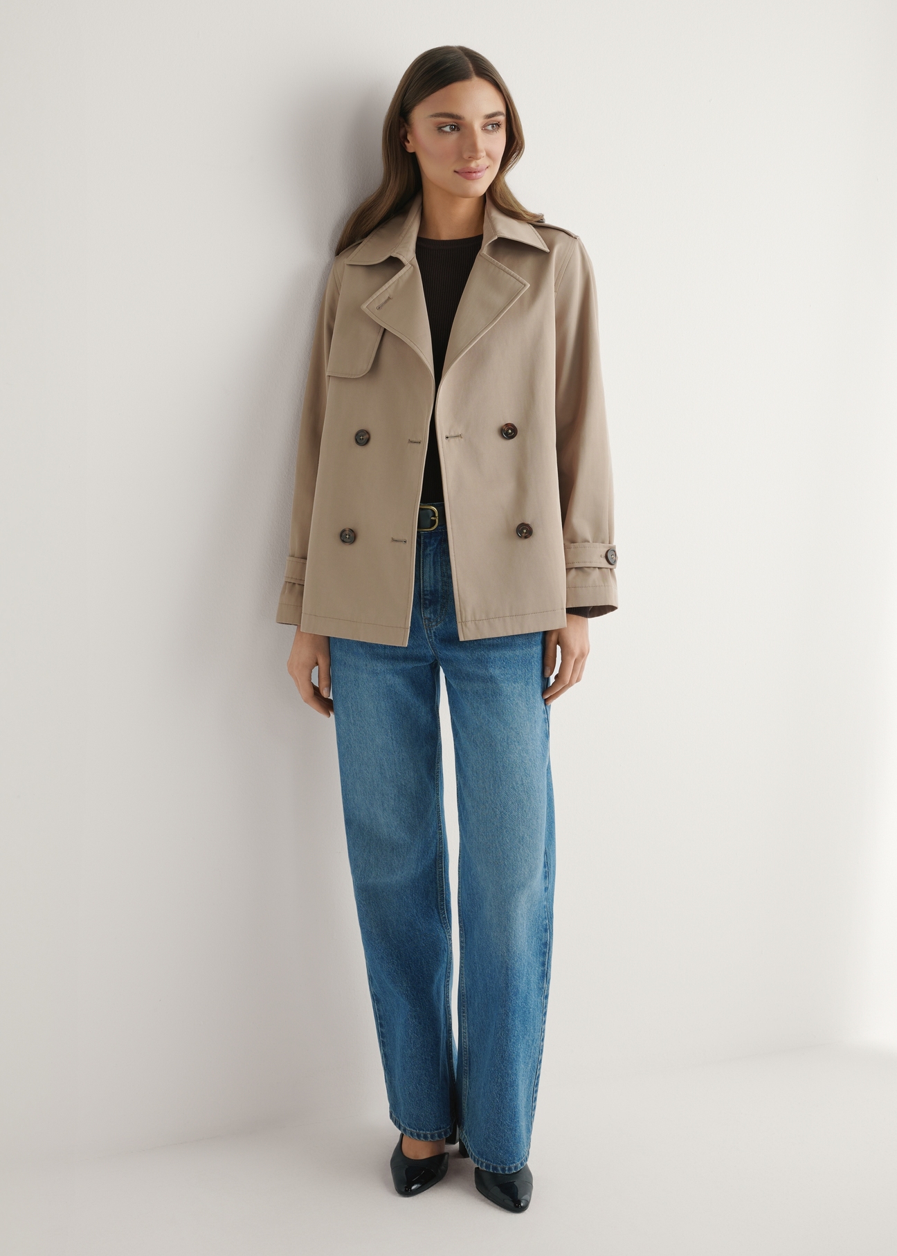 Dámska béžová krátka bunda KURDT-0556-1C(W26), pohľad spredu na produkt na modelke. Viditeľné celé telo.