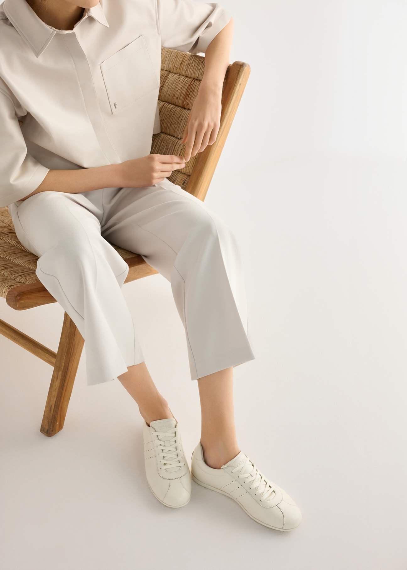 Dámske kožené topánky krémovej farby BUTYD-1261-0B(W26), pohľad zhora na produkt na nohách modelky, na svetlom pozadí.