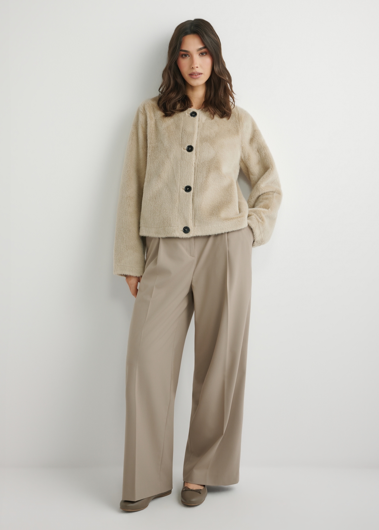 Dámsky krátky béžový kožuch FUTDP-0079-1A(W26), pohľad spredu na výrobok na modelke. Viditeľné celé telo.