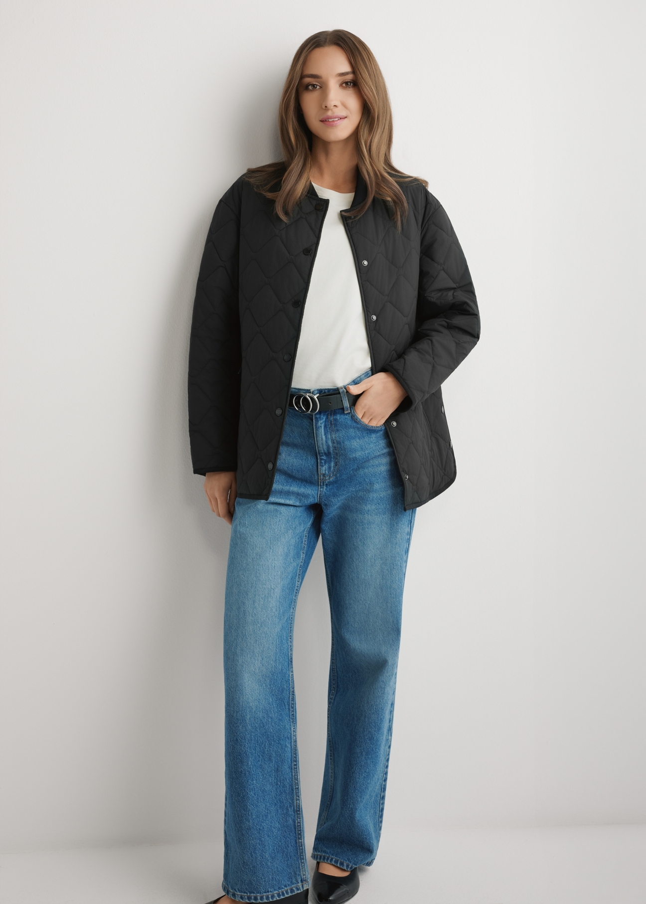 Dámska čierna prešívaná bunda KURDT-0580-99(W26) - pohľad spredu na výrobok, na modelke, na svetlom pozadí. Viditeľné celé telo.