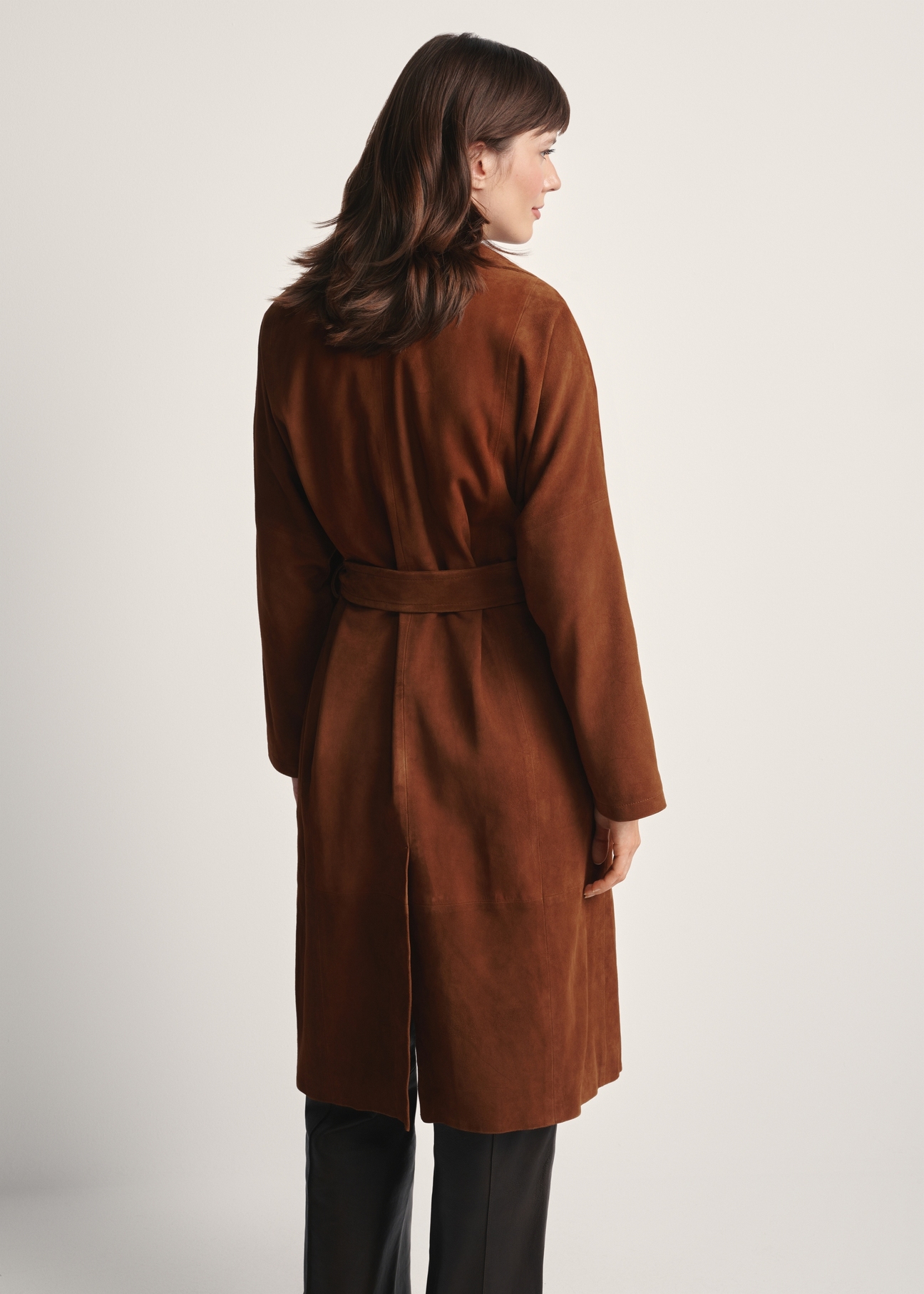 Dámsky hnedý semišový kabát oversized KURDS-0551-0775(Z25), pohľad na produkt zozadu na modelke. Viditeľná polovica siluety.