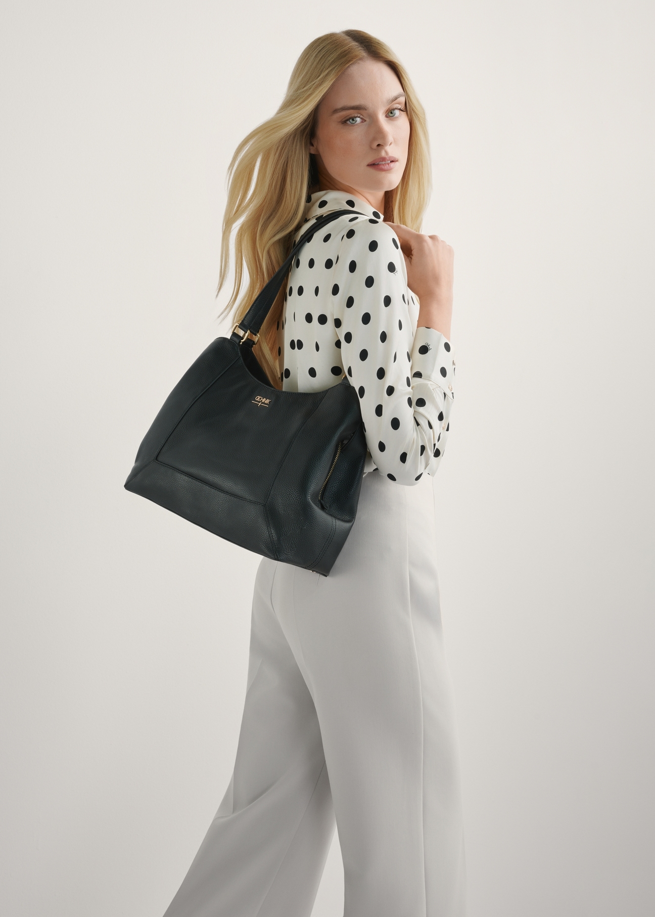 Dámska čierna kožená nákupná kabelka TORES-1264-9I(W26), pohľad na produkt na ramene modelky. Viditeľná polovica siluety.