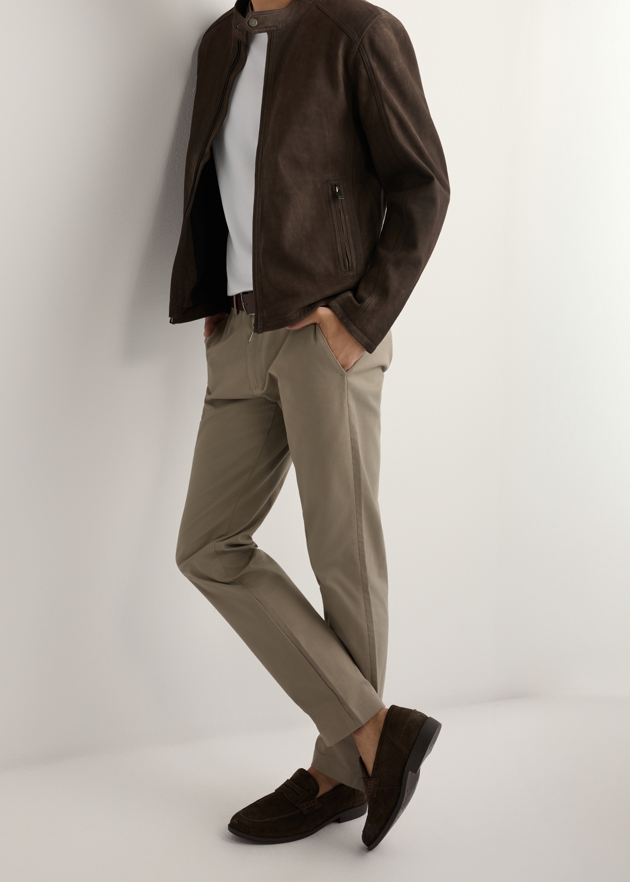 Pánske tmavohnedé kožené mokasíny BUTYM-0482-1H(W26), bočný pohľad na produkt na nohách modelky, na svetlom pozadí.