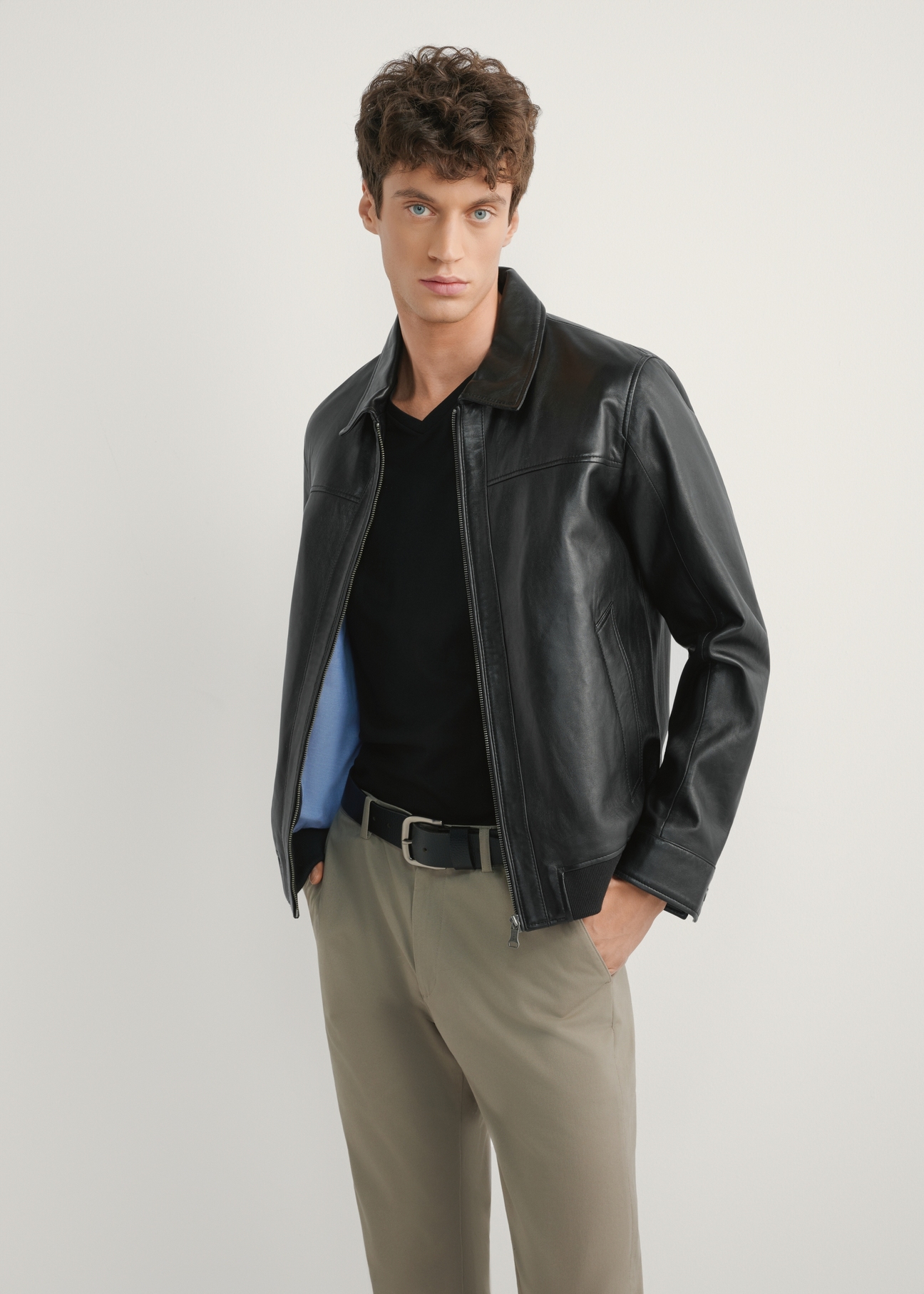 Čierna pánska kožená bunda KURMS-0407-99(W26), pohľad spredu na modelku. Viditeľná polovičná silueta.