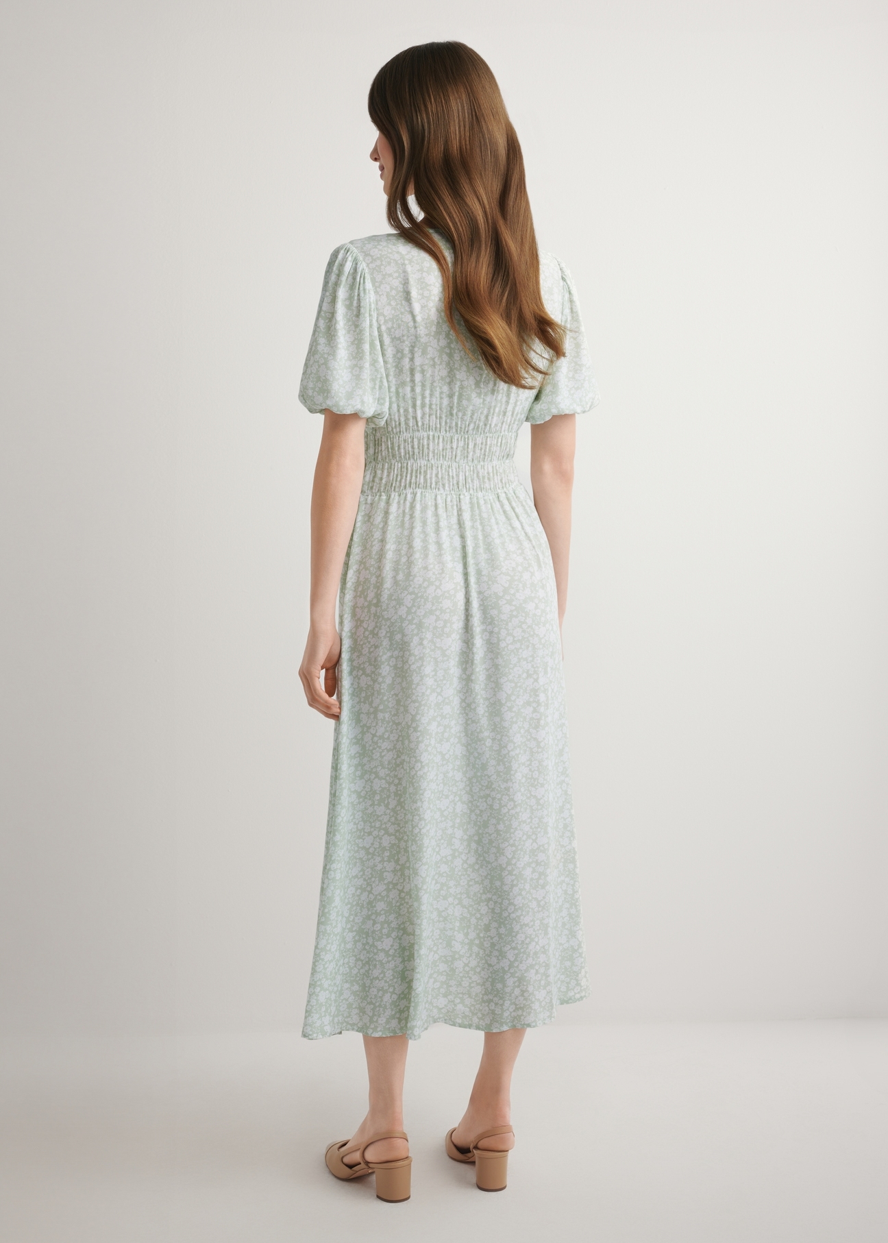 Dlhé kvetinové šaty v šalviovej farbe SUKDT-0191-8P(W26), pohľad zozadu na modelku. Viditeľné celé telo.