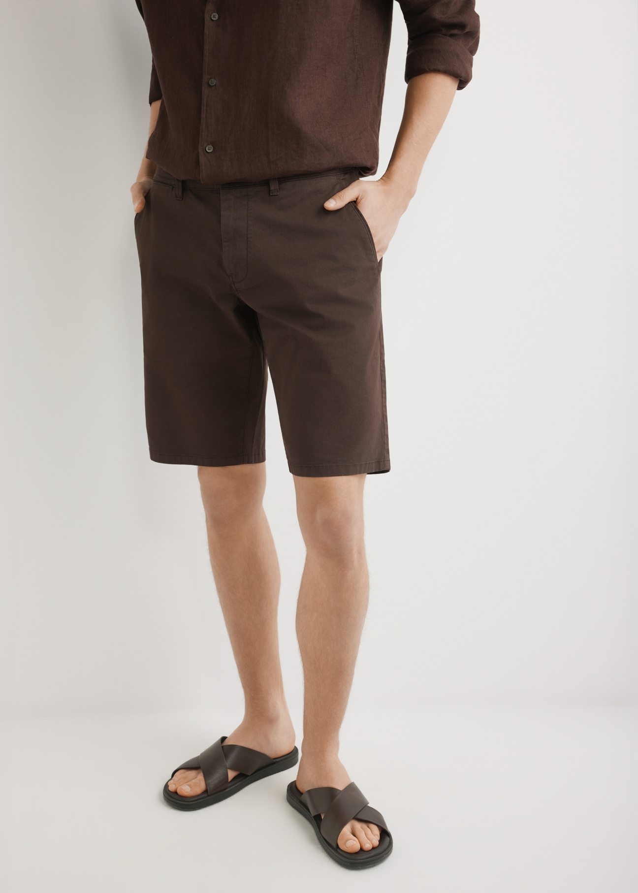 Pánske hnedé šortky SZOMT-0029-1I(W26), pohľad spredu na produkt na modeli. Viditeľná polovica siluety.