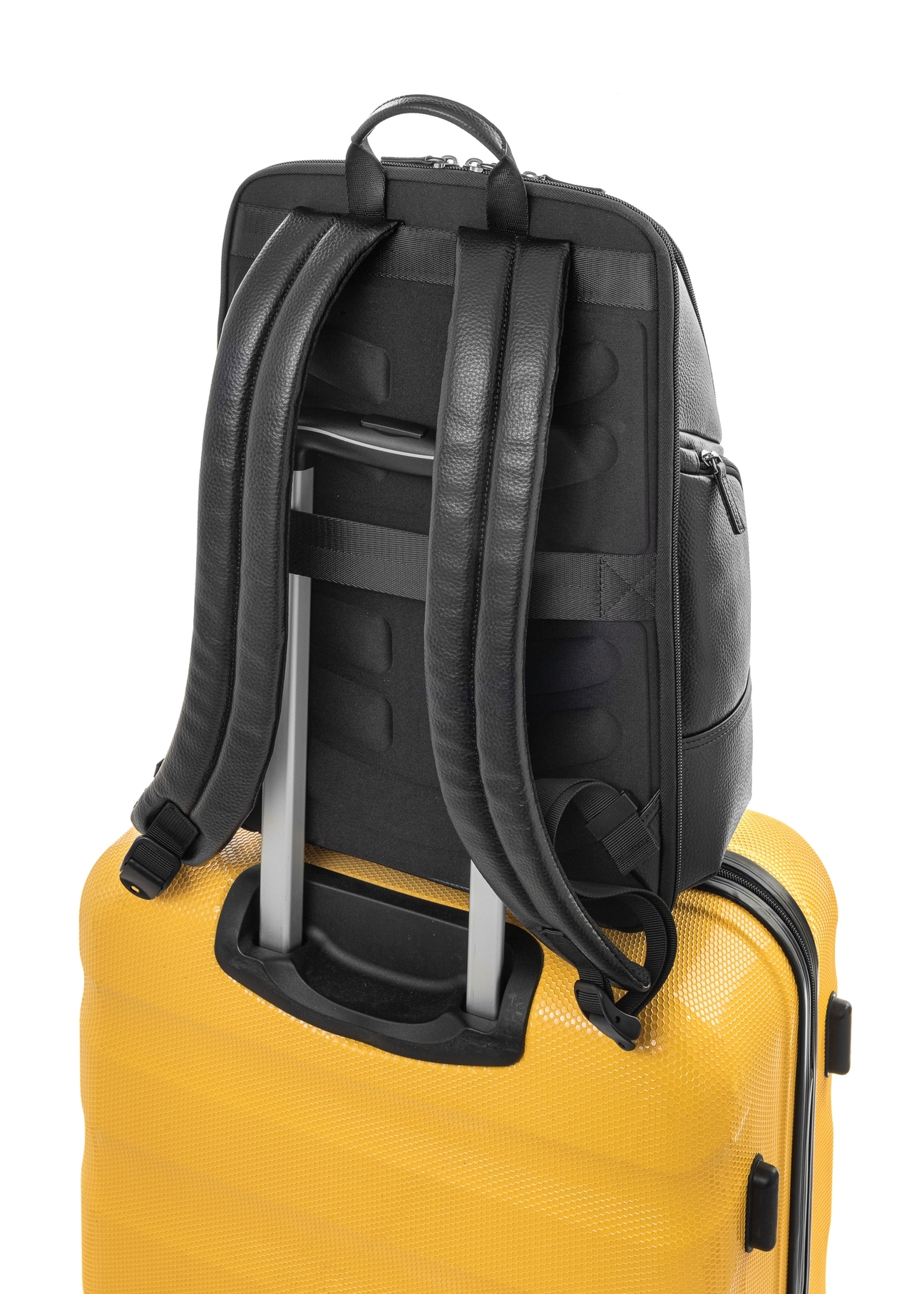 Čierny priestranný kožený batoh PLCMS-0023-99(Z25), pohľad na produkt zozadu na kufri na bielom pozadí.