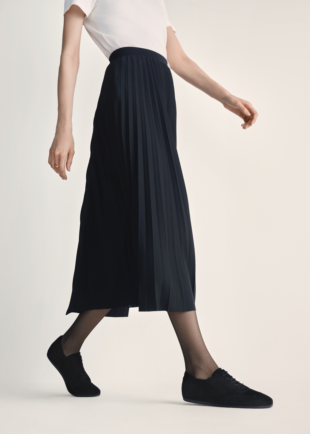 Dámske kožené topánky v čiernej farbe BUTYD-1215-99(Z25), pohľad na produkt na nohách modelky na svetlom pozadí.