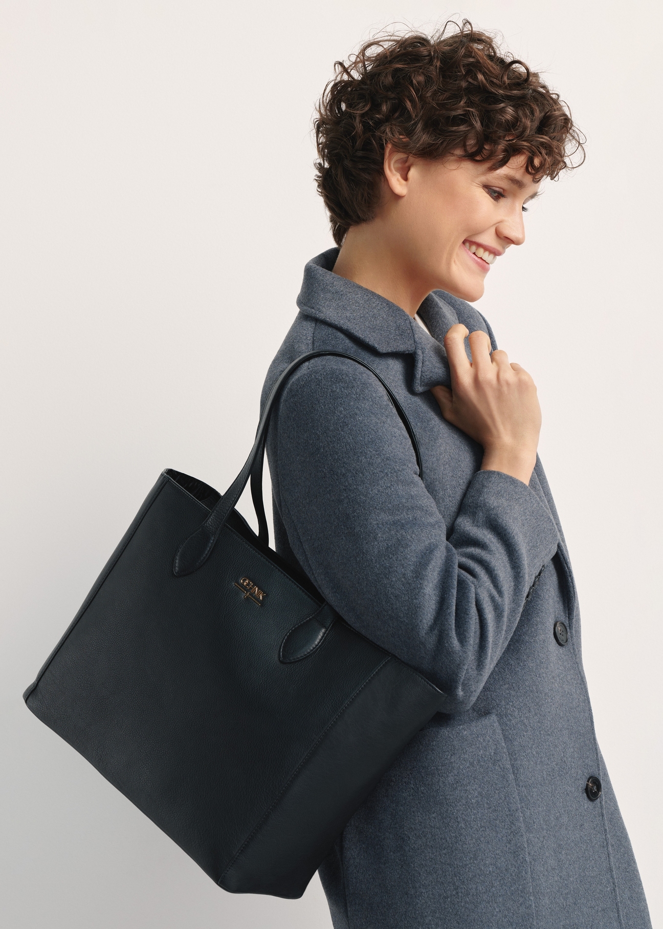 Čierna kožená dámska nákupná taška TORES-0971F-99(W26), pohľad spredu na produkt na modelke, viditeľná polovica siluety.