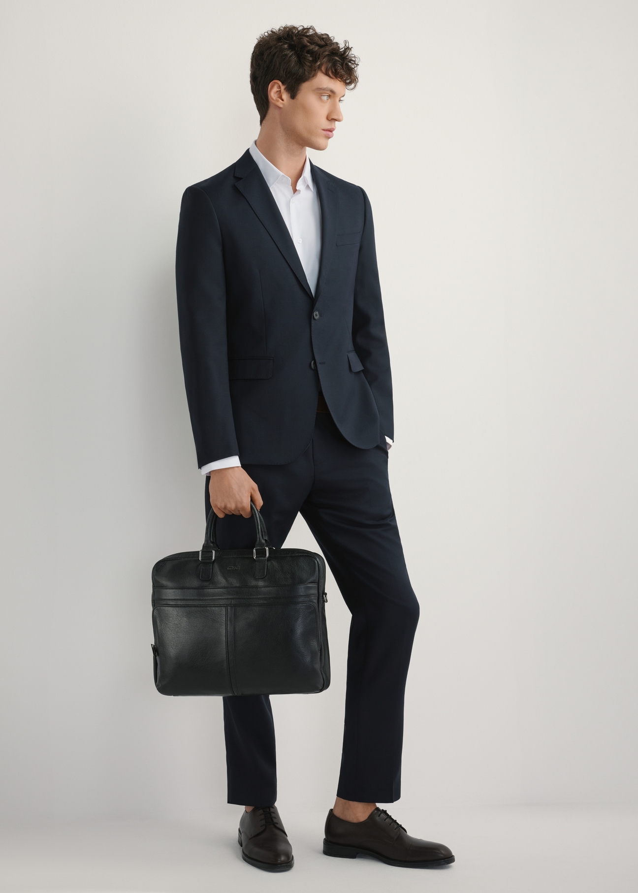 Čierna kožená pánska taška TORMS-0456-99(W25), pohľad na produkt spredu na modeli, viditeľná celá silueta.