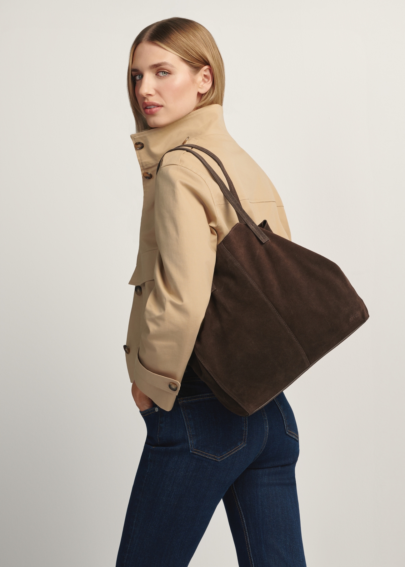 Dámska kabelka TORES-1252-1I(W26) z tmavohnedej kože - diagonálny pohľad na produkt, na modeli, na bielom pozadí. Viditeľná silueta po kolená.