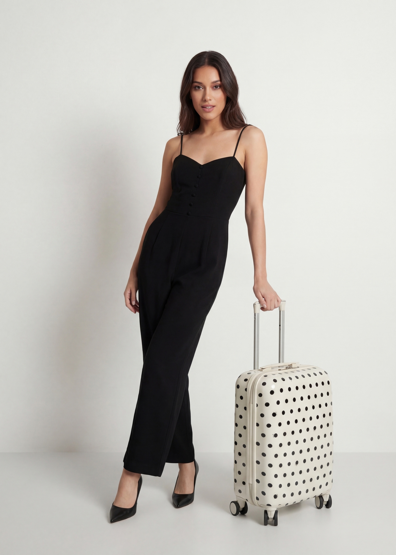 Malý bodkovaný kufor na kolieskach WALAB-0074-0P-19(W26), diagonálny pohľad na produkt vedľa siluety modelky.