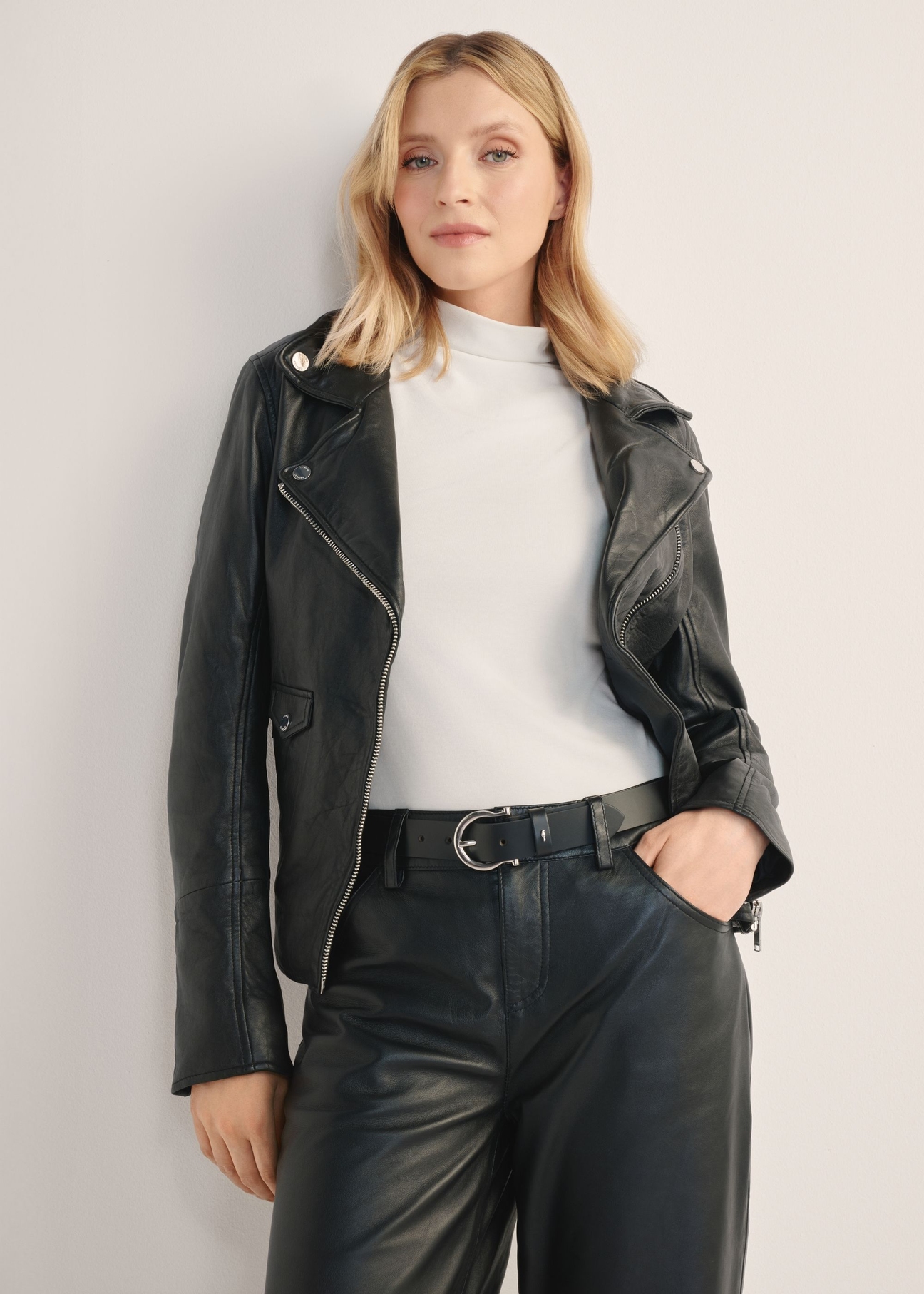 Dámska čierna kožená bunda KURDS-0184-99(KS), pohľad spredu na produkt na modelke. Viditeľná polovica siluety.