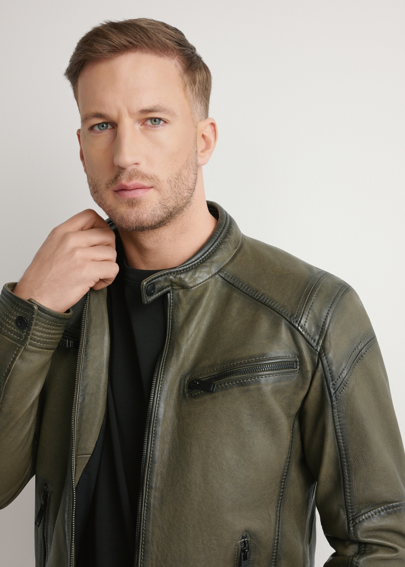 Pánska khaki kožená bunda KURMS-0403-8D(W26) - pohľad spredu na výrobok, na modelke, na svetlom pozadí. Viditeľná polovica siluety.