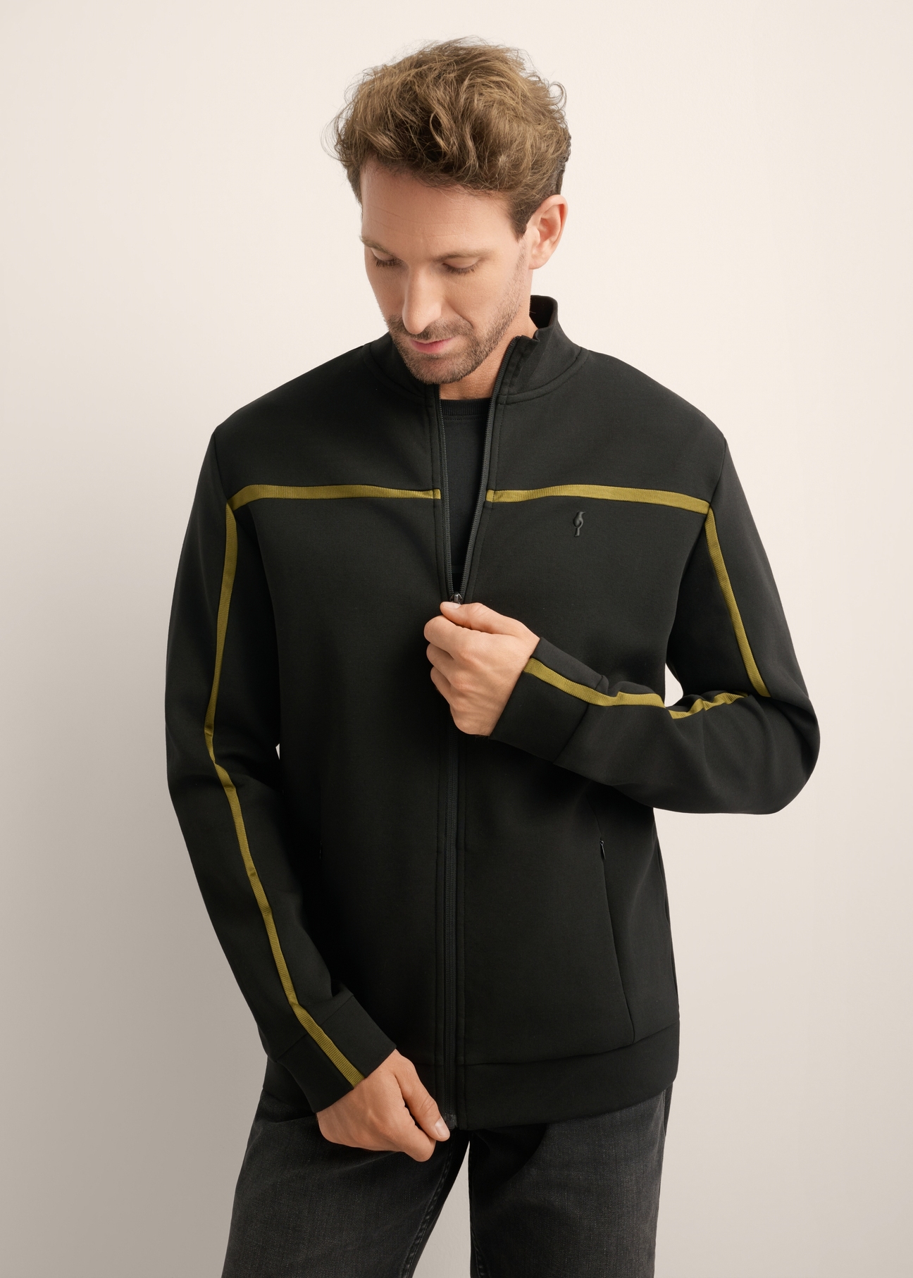 Pánska čierna mikina na zips so stojačikom BLZMT-0082-99(Z26), pohľad spredu na produkt na modelke. Viditeľná polovica siluety.