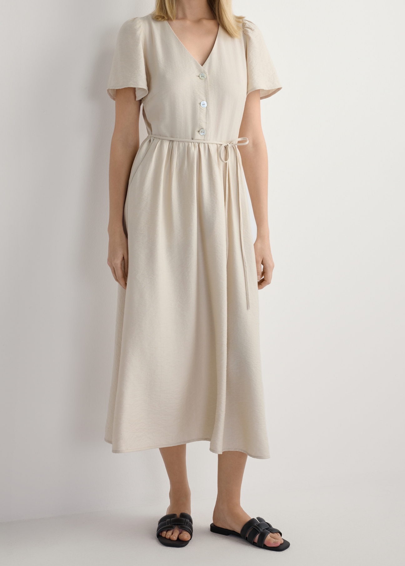 Dámske čierne kožené pletené šľapky BUTYD-1225-99(W26), pohľad spredu na produkt na nohách modelky, na bielom pozadí. Viditeľná polovica siluety.