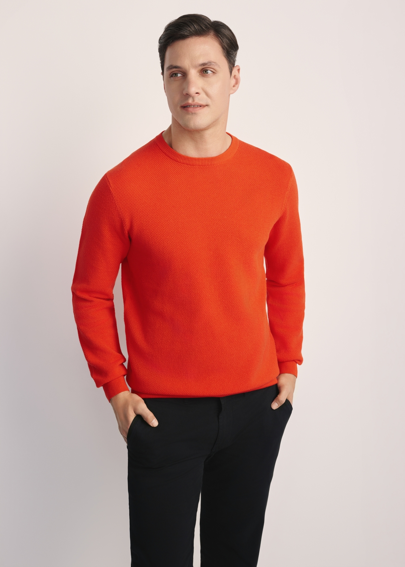 Oranžový pánsky sveter SWEMT-0181-30(Z25), pohľad spredu na modelku. Viditeľná polovica siluety.