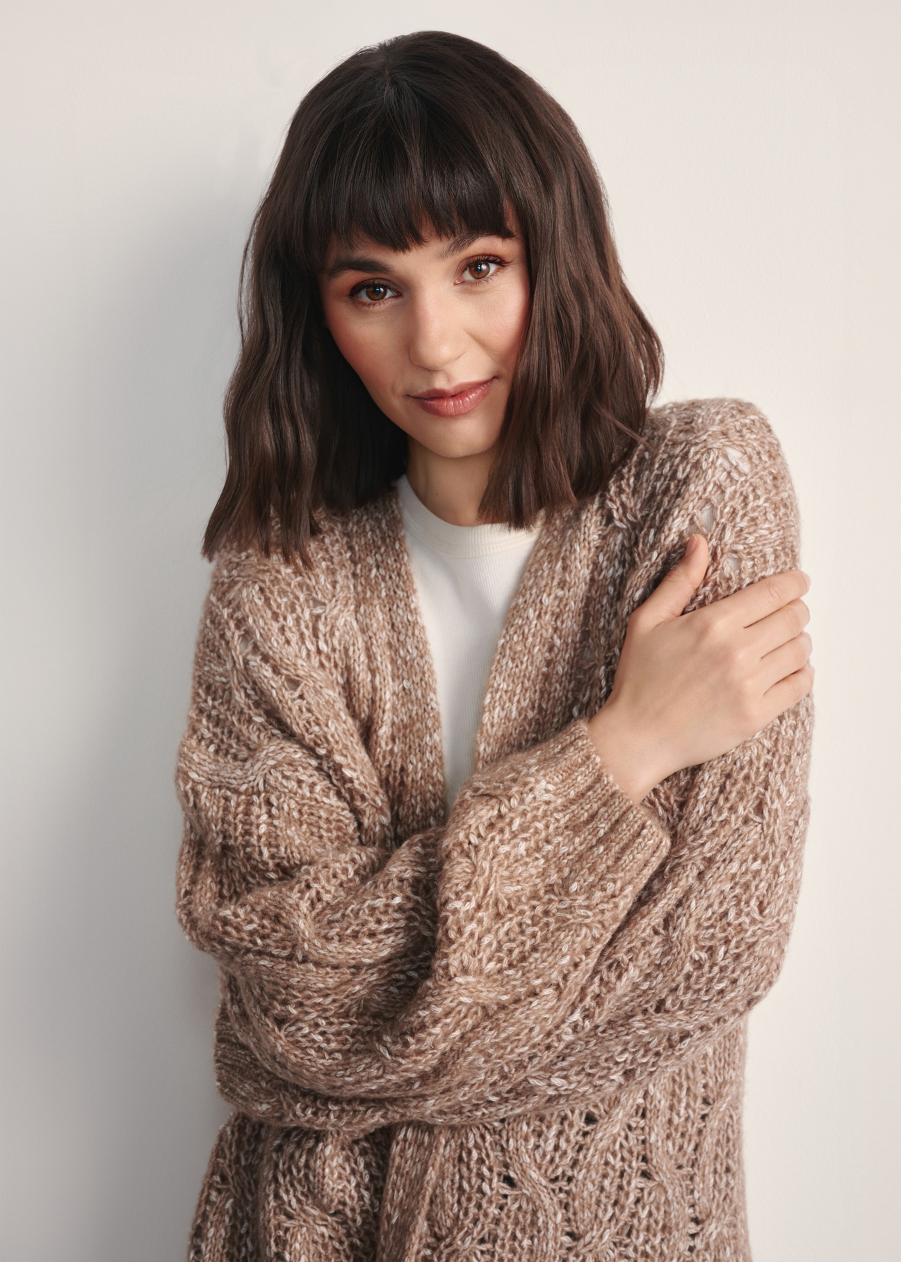 Dámsky dlhý kardigan v ťavej farbe KARDT-0055-24(Z25), detailný záber na produkt na modelke. Viditeľná polovica siluety.