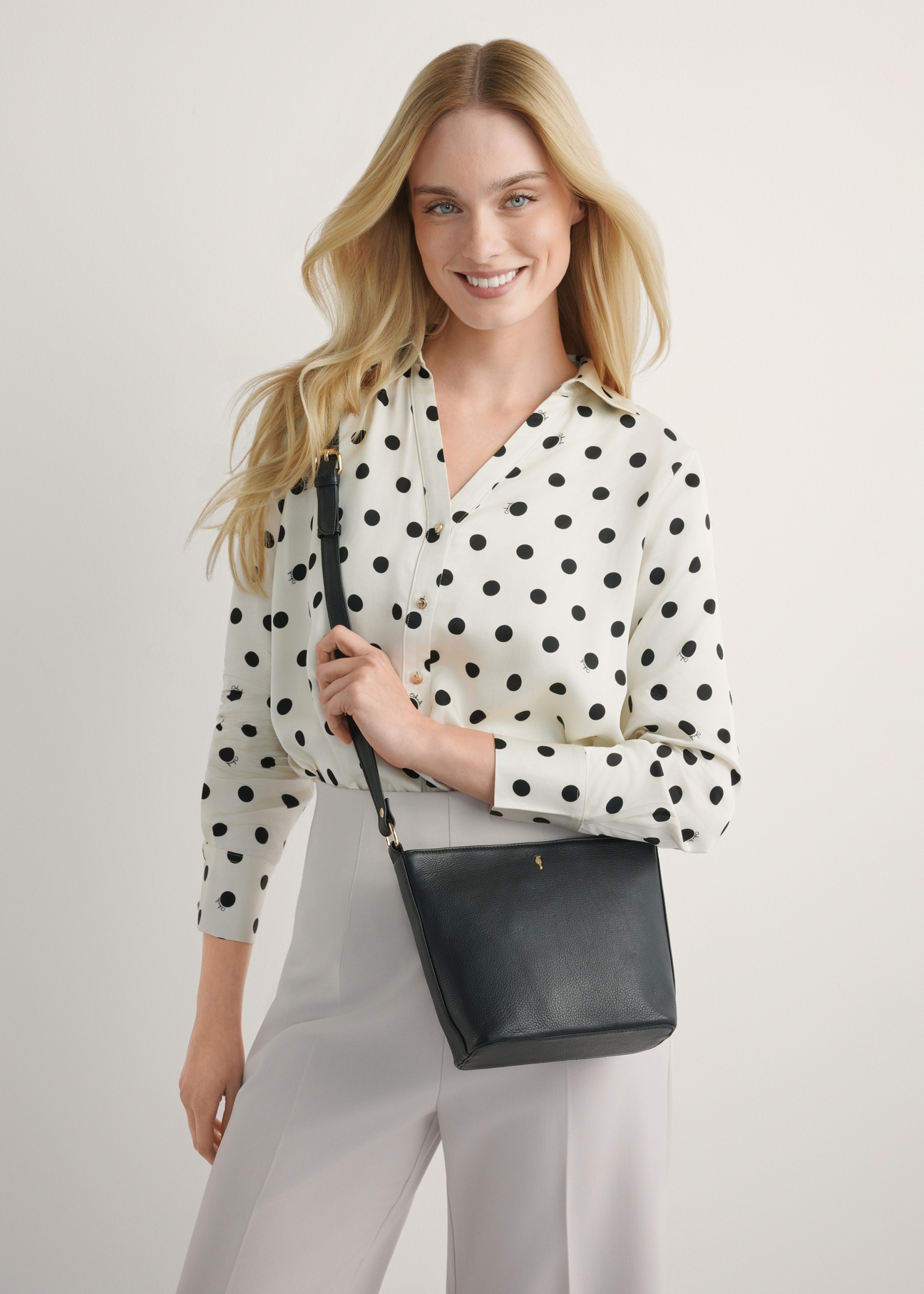 Čierna kožená kabelka cez rameno TORES-1280-99(W26), pohľad na produkt na siluete modelky, na svetlom pozadí.