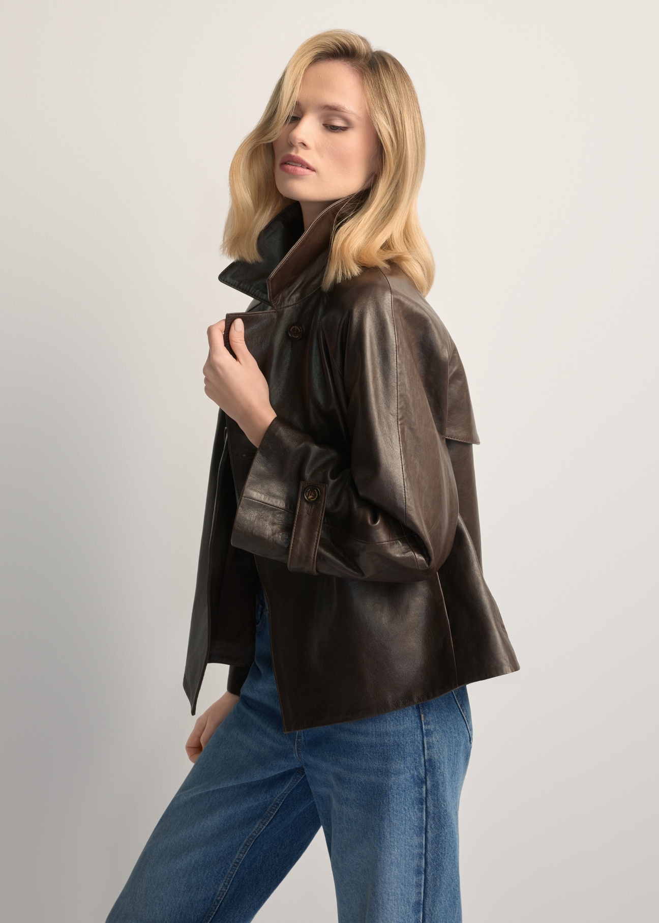 Dámska tmavohnedá kožená bunda KURDS-0604-1I(W26), bočný pohľad na produkt na modelke. Viditeľná polovica siluety.