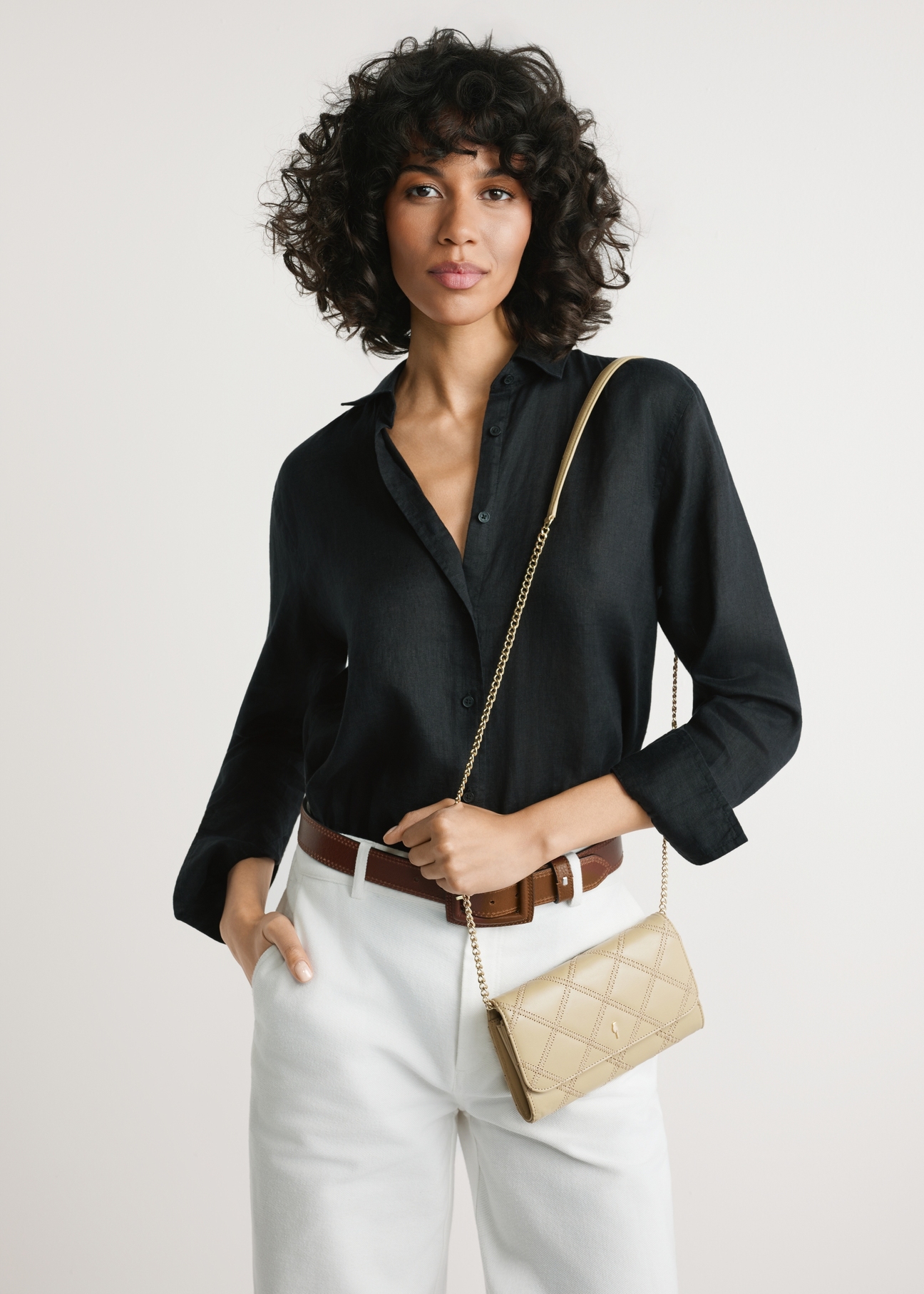 Malá béžová dámska kožená kabelka TORES-1043-1B(W26) - pohľad spredu na produkt, na modelke, na svetlom pozadí. Viditeľná silueta po kolená.