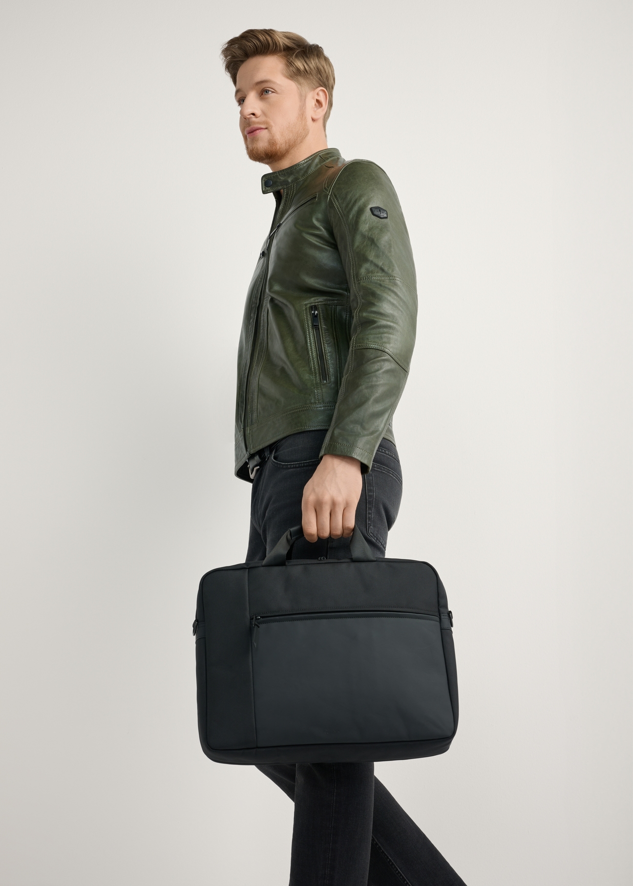 Čierna taška na notebook TORMN-0401-99(W26) - pohľad spredu na produkt, ktorý drží modelka, na svetlom pozadí. Viditeľná je polovica siluety.