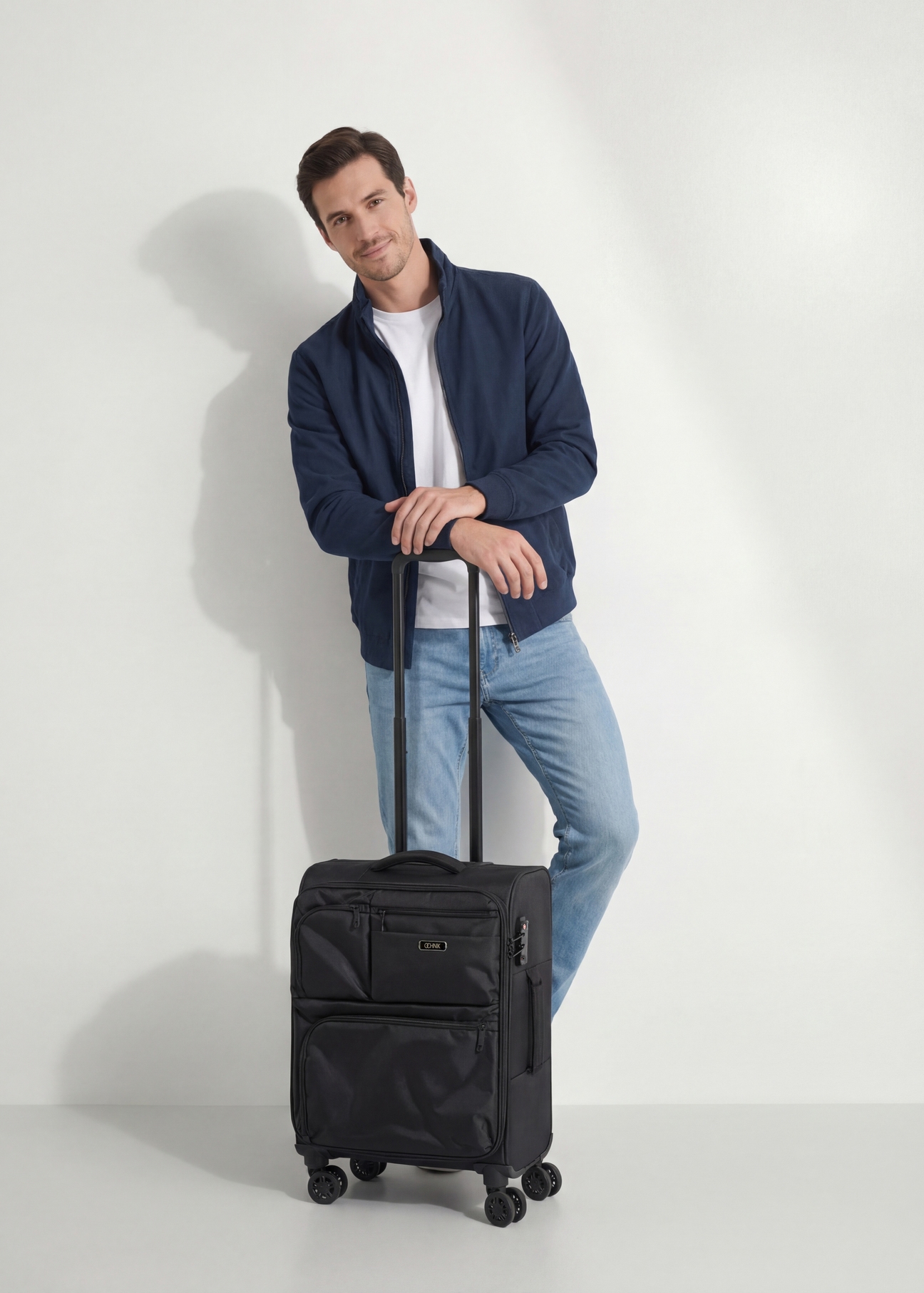 Malý kufor na kolieskach WALNY-0048-99-19(W26), diagonálny pohľad na produkt vedľa siluety modelky.