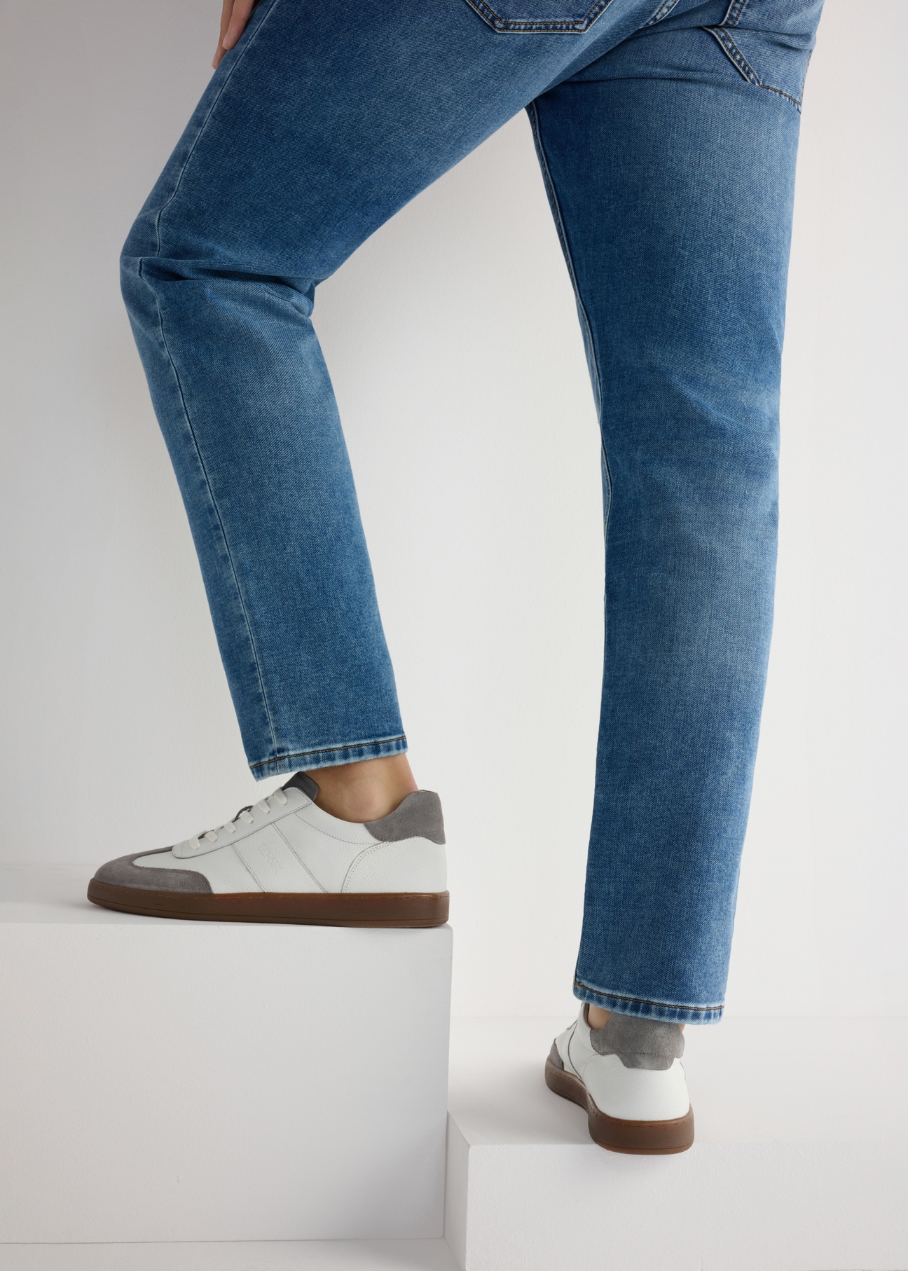 Pánska kožená športová obuv BUTYM-0487-0B(W26), pohľad na produkt na nohách modelky, na svetlom pozadí.