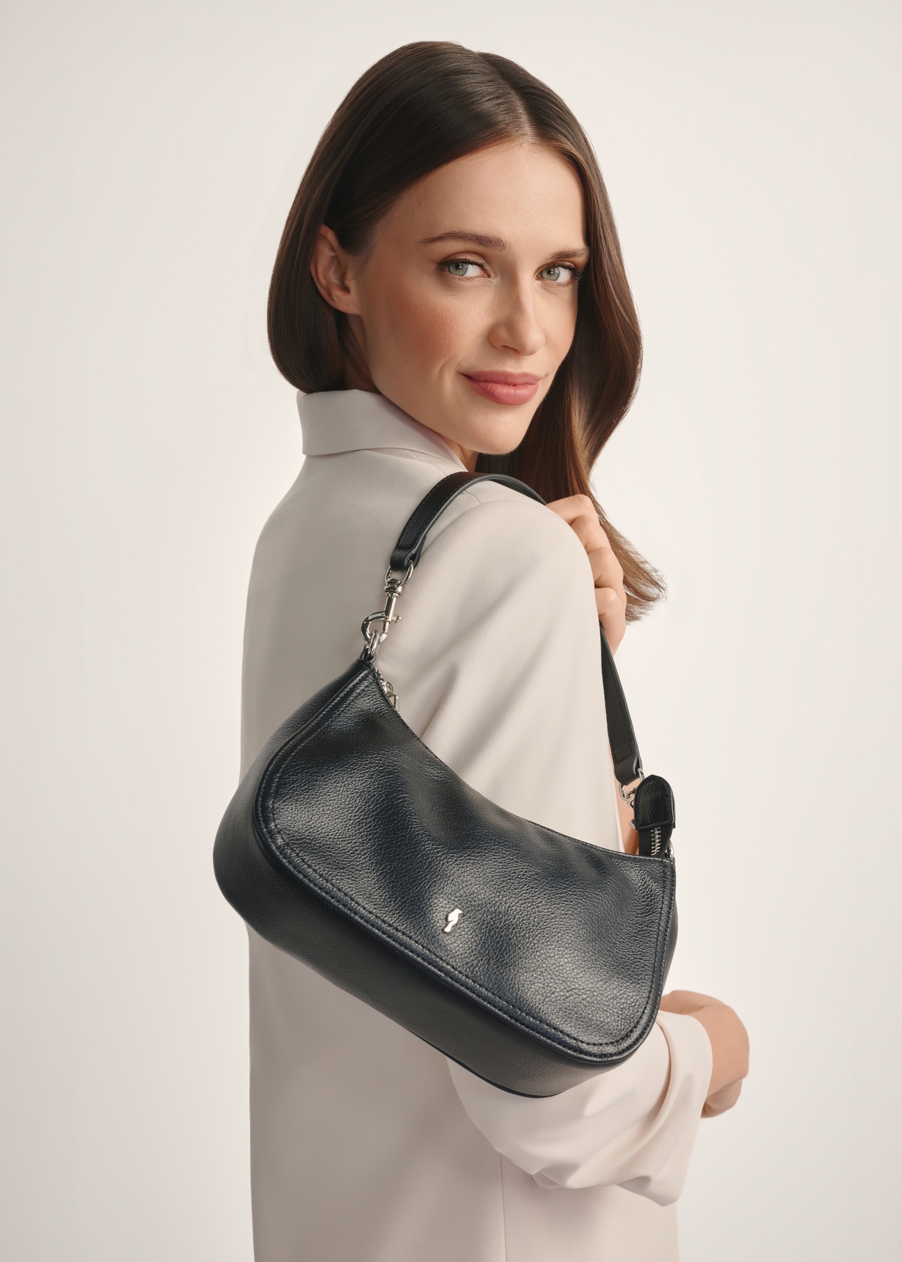 Malá čierna dámska kabelka TOREC-1134-99(W26) - pohľad spredu na produkt, na modeli, na bielom pozadí. Viditeľná polovica siluety.