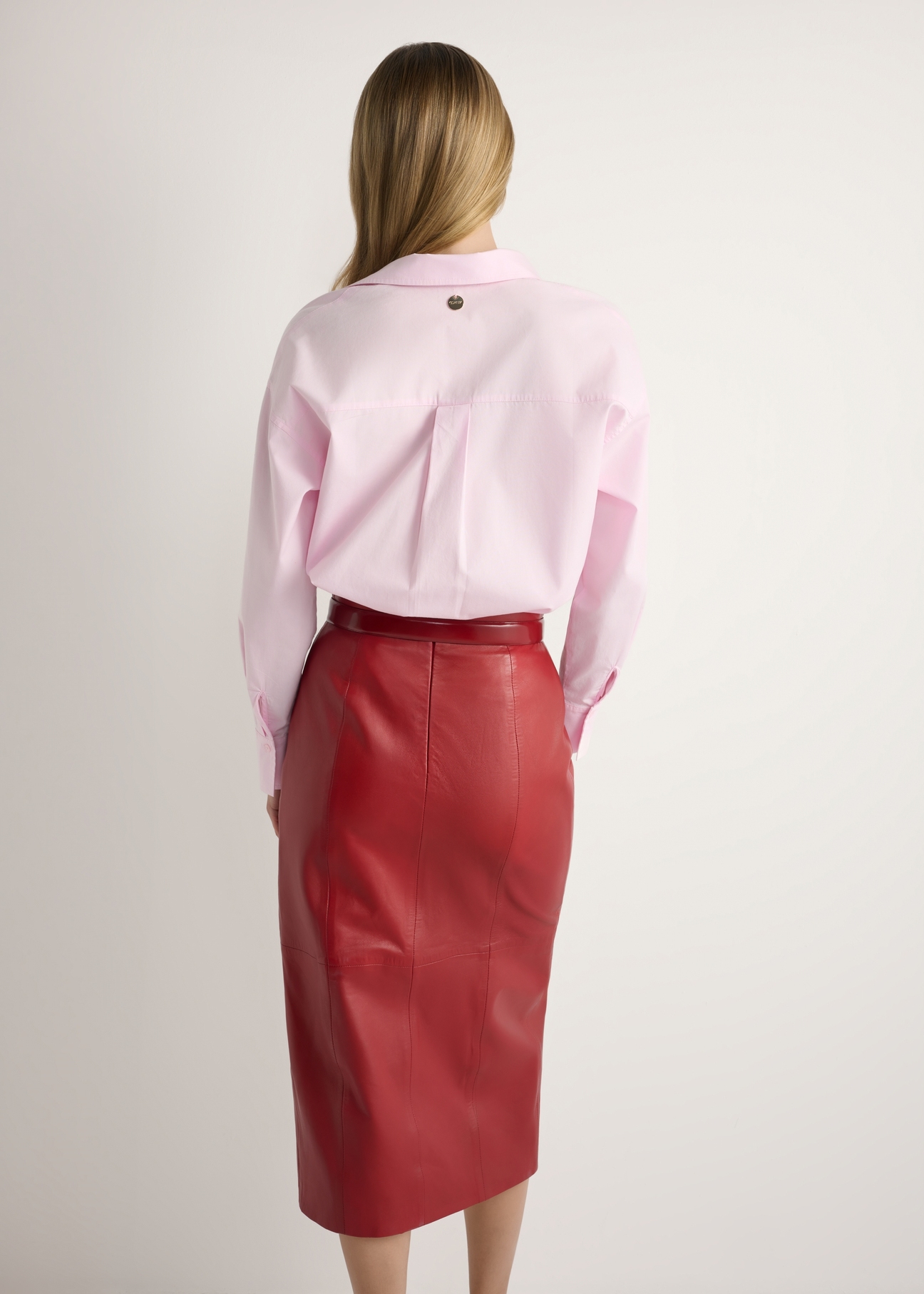 Dámska bavlnená košeľa svetloružovej farby KOSDT-0181-5A(W26), pohľad na produkt zozadu na modelke. Viditeľná polovica siluety.